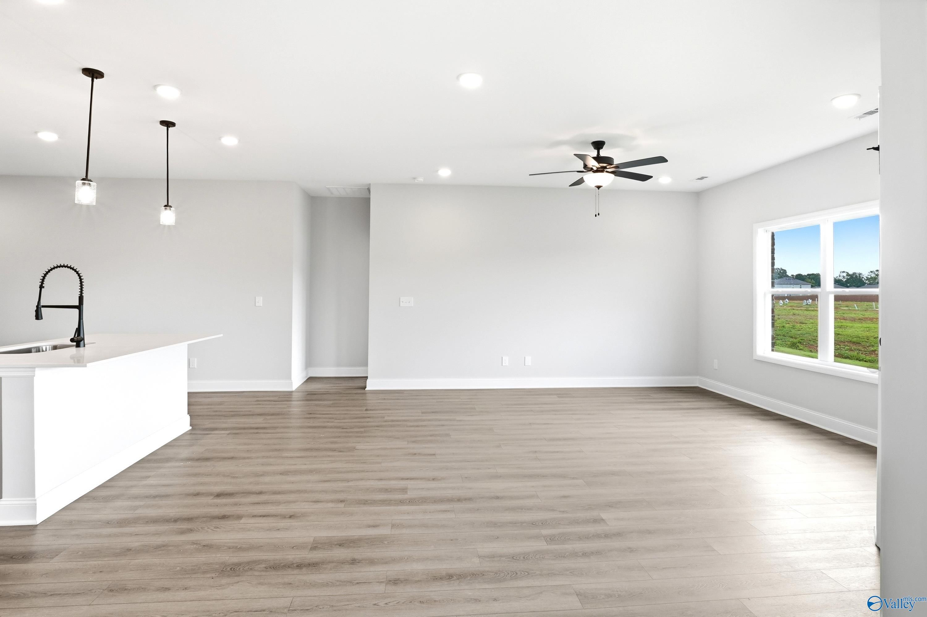 Open-concept living room and kitchen in The Daphne floor plan by Davidson Homes in Lynn Meadows, Meridianville, Alabama.