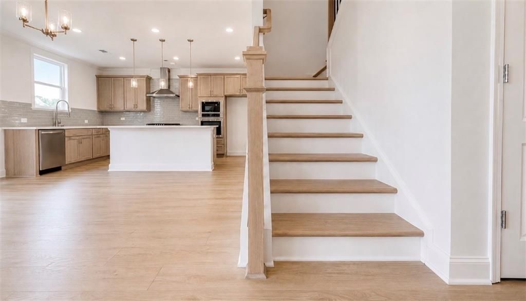Open-concept floor plan with staircase and modern kitchen in Davidson Homes Hickory C model, Wehunt Meadows, Hoschton, GA.