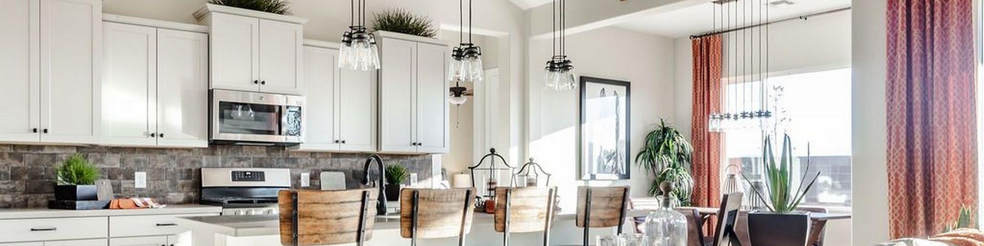 Open-concept kitchen and living room at Westwood in Prescott AZ with white cabinets, island bar stools, exposed beams, and cozy seating