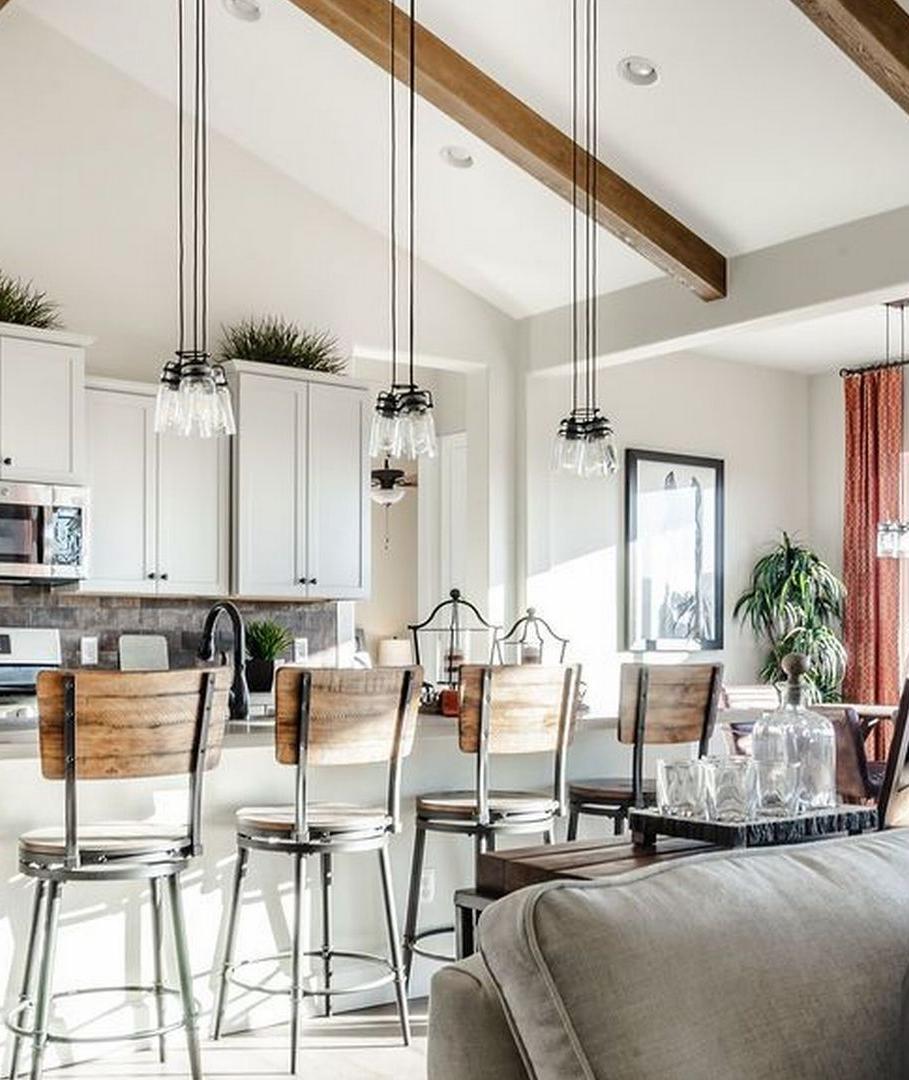Open-concept kitchen and living room at Westwood in Prescott AZ with white cabinets, island bar stools, exposed beams, and cozy seating