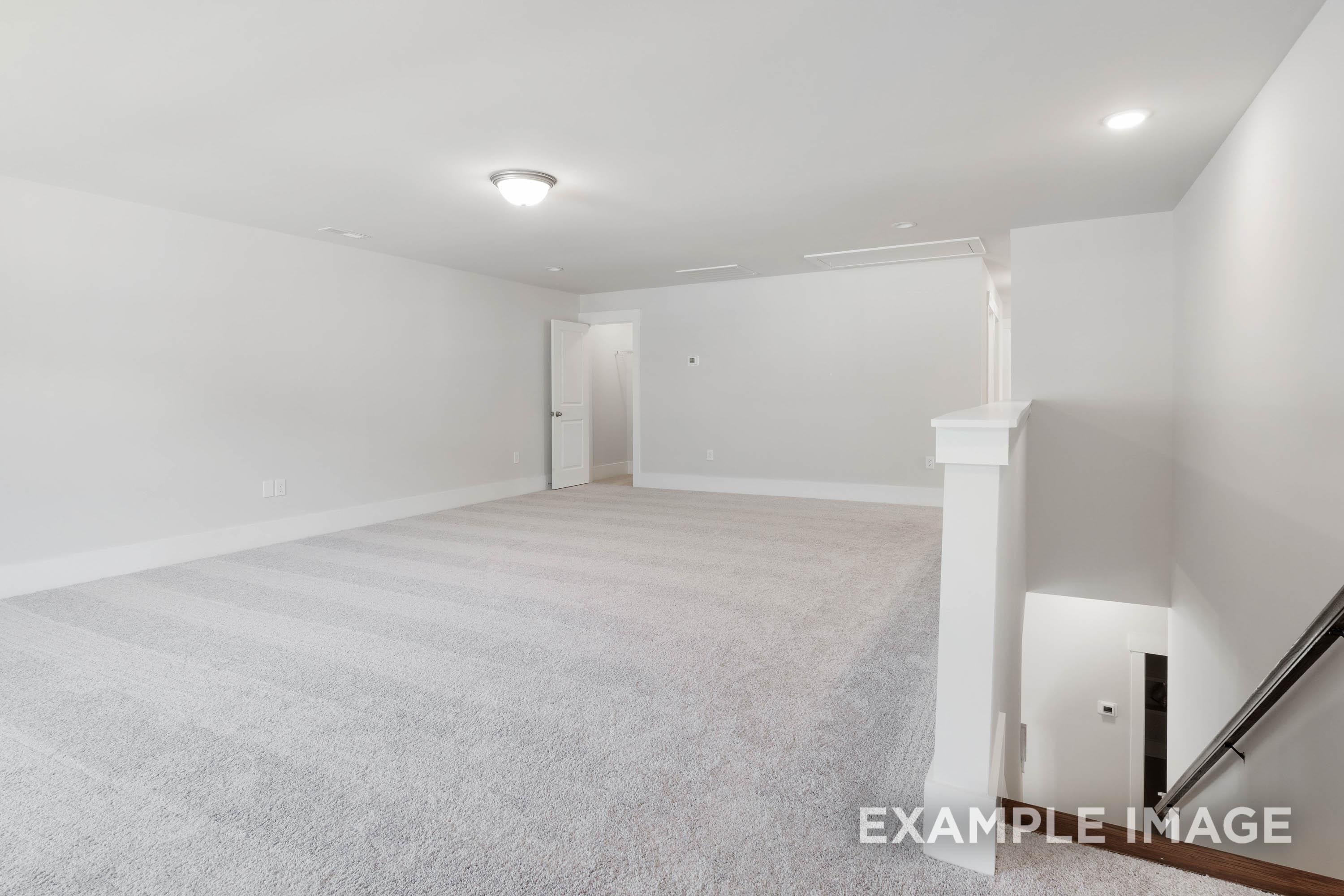 Spacious carpeted loft area in The Richmond D floor plan by Davidson Homes featuring neutral walls and staircase access.