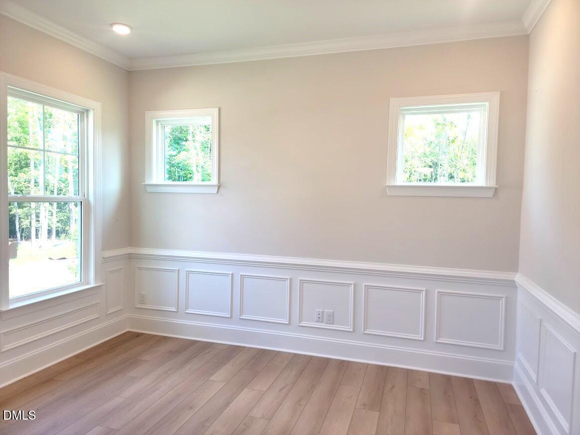 Bright dining room with wainscoting, crown molding, and hardwood floors in Davidson Homes The Crawford D, Wake Forest, NC