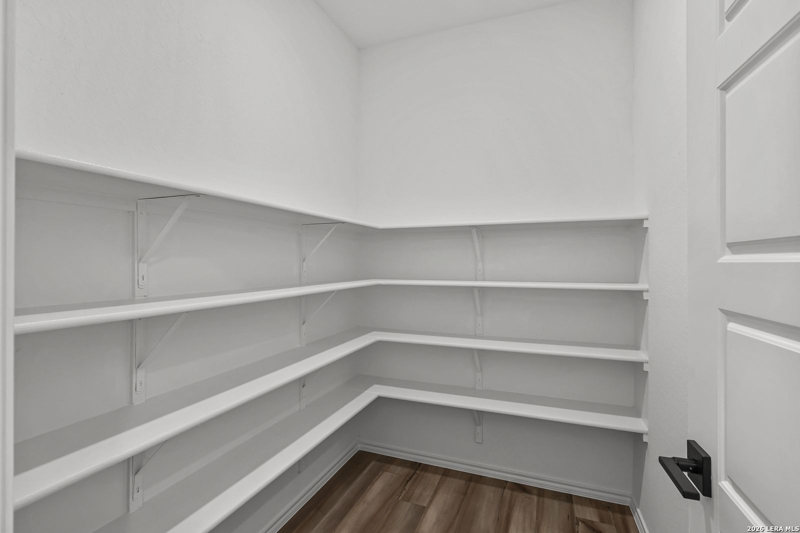 Walk-in pantry with white wrap-around shelving in The Gillian C floor plan at Meadows at Oak Creek, San Antonio, Texas.