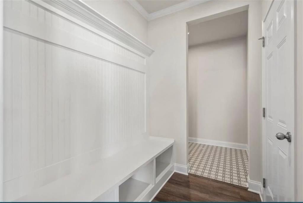 White mudroom bench with beadboard trim and storage cubbies in The Ash C floor plan at Wehunt Meadows, Hoschton, Georgia.