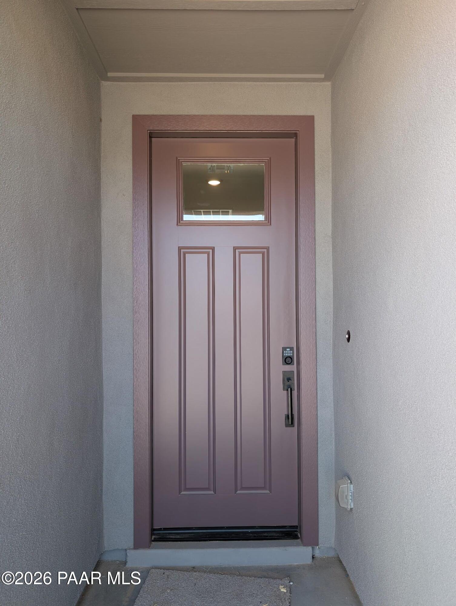 Modern front entryway with a dark mauve door at The Frontier II F home in South Ranch, Prescott, Arizona.