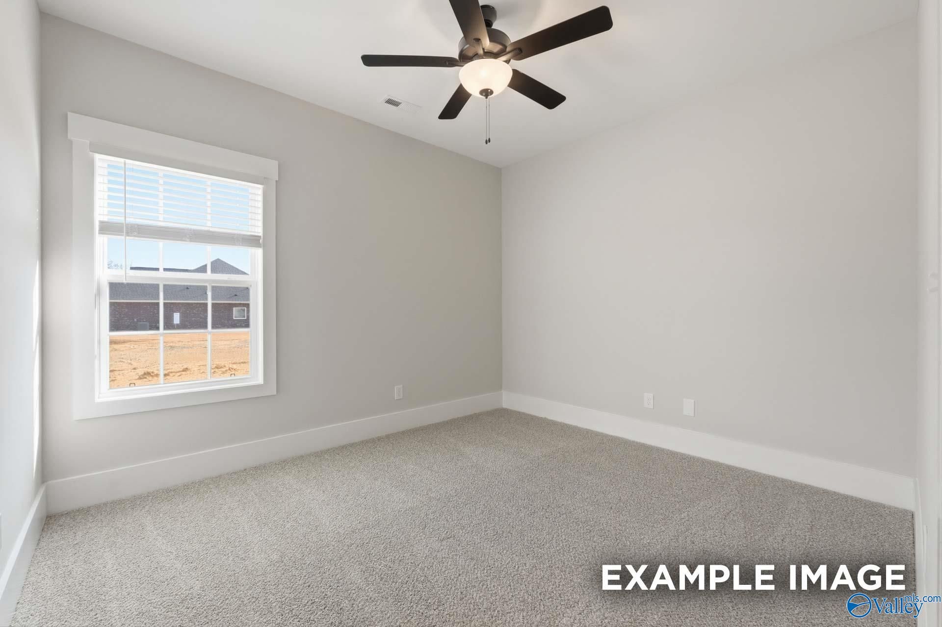 Bright bedroom with neutral carpet and ceiling fan in The Rockford floor plan by Davidson Homes in Briercreek, Meridianville.