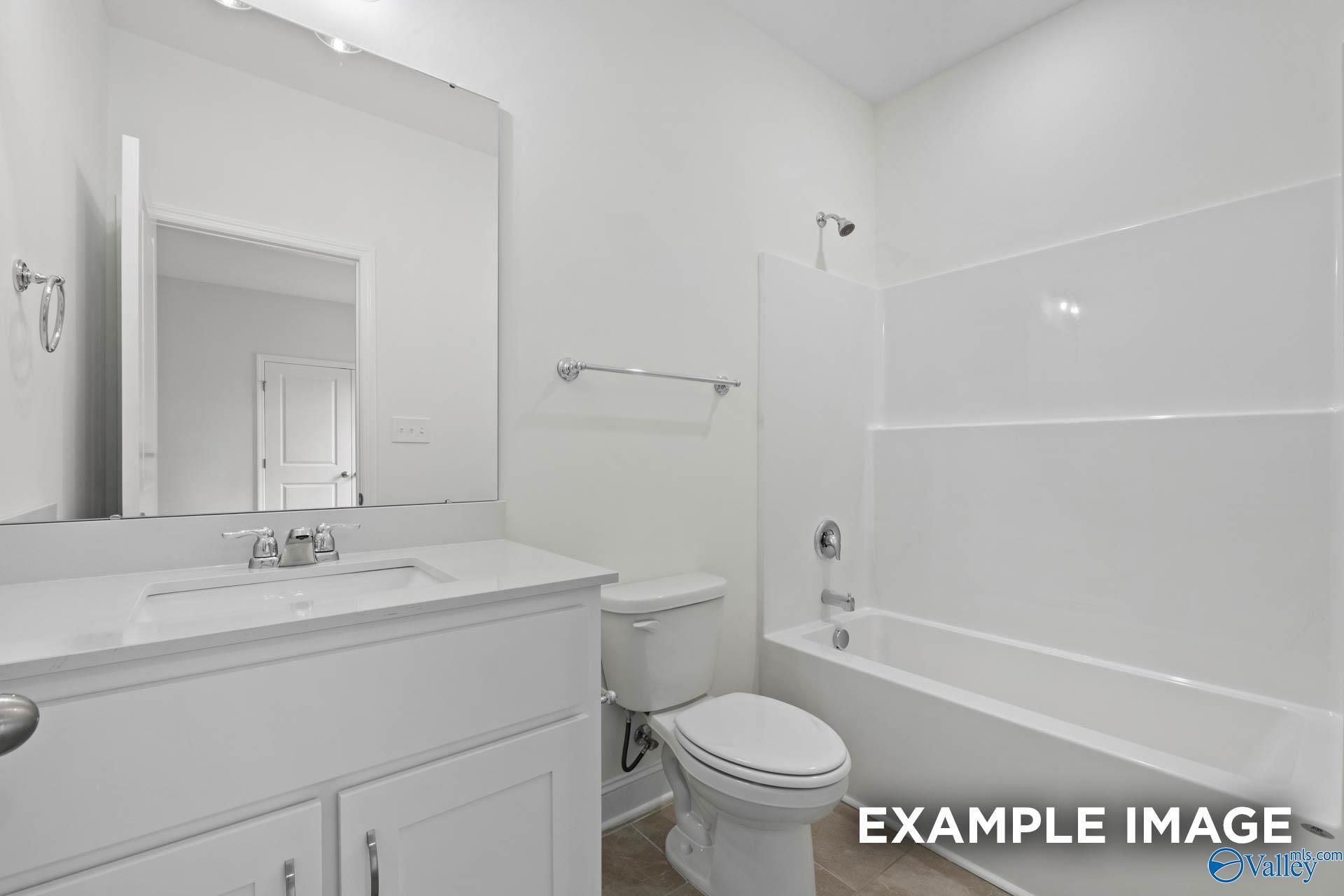 Bright white bathroom with bathtub, walk-in shower, vanity, and toilet in Davidson Homes The Oxford, Riverton Preserve, Huntsville