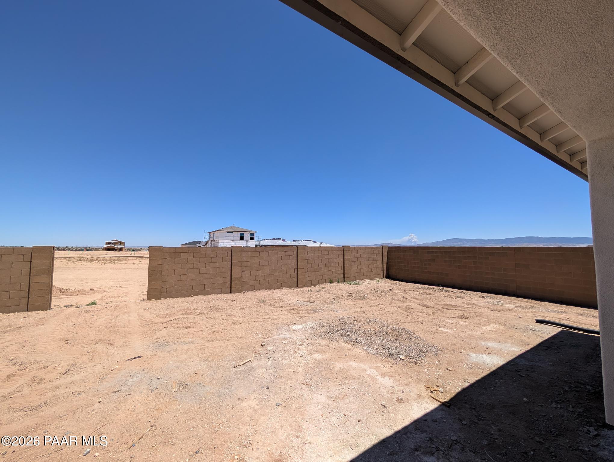 Unfinished backyard with block wall fencing at The Durango II G floor plan in South Ranch, Prescott, Arizona.