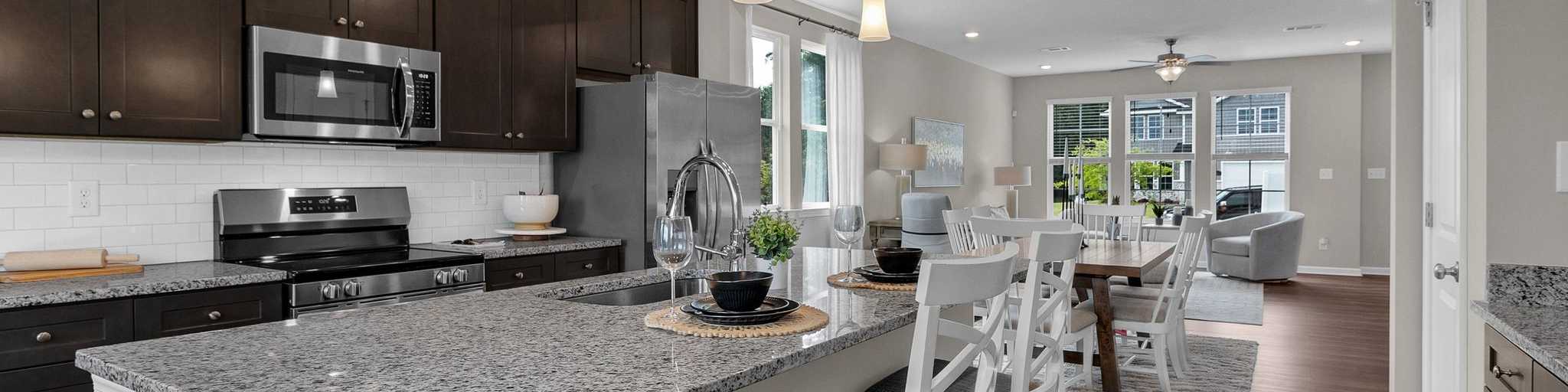 Spacious open-concept kitchen at Ivy Glen in Perry Georgia with granite island, dark cabinets, and hardwood floors