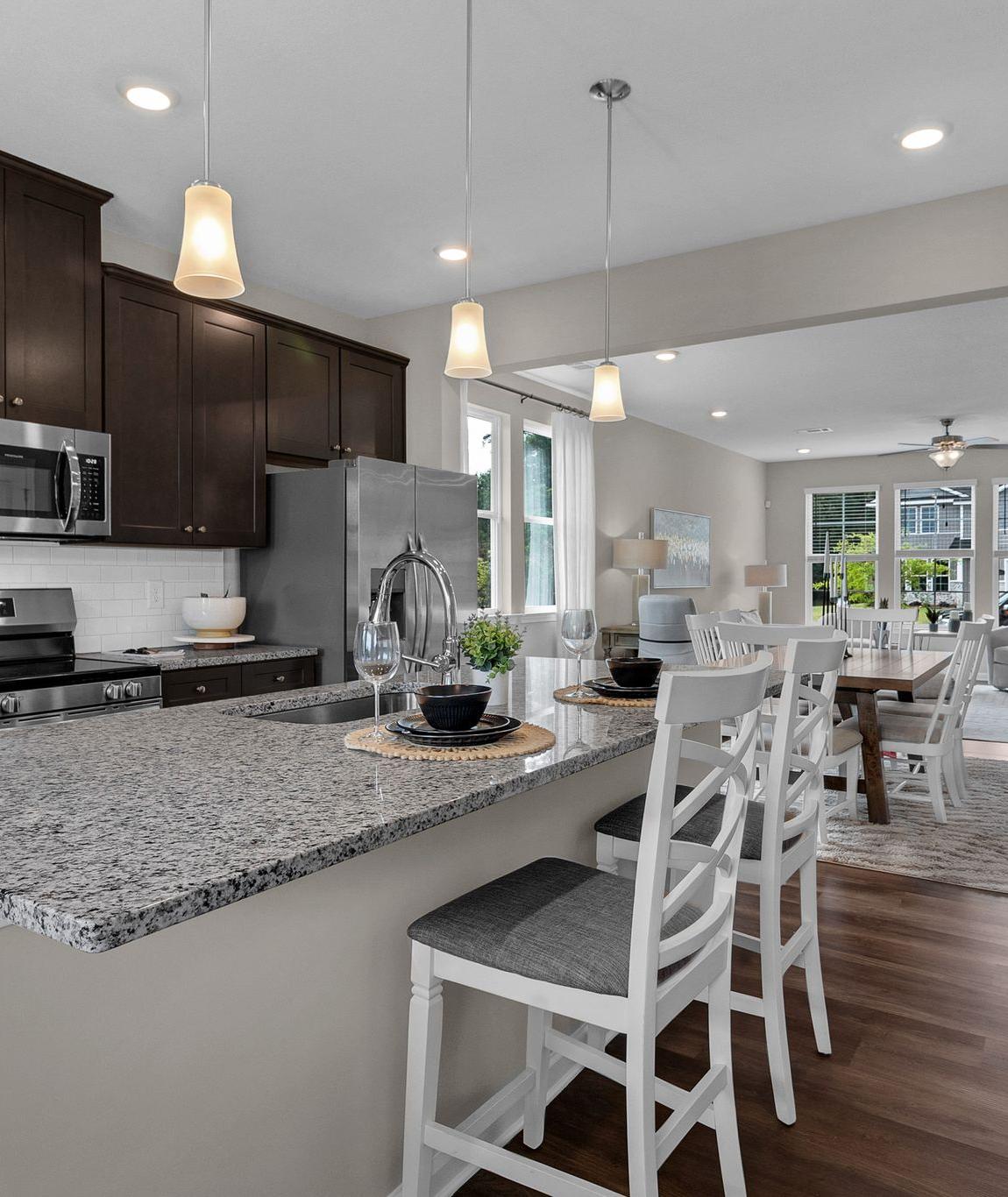 Spacious open-concept kitchen at Ivy Glen in Perry Georgia with granite island, dark cabinets, and hardwood floors