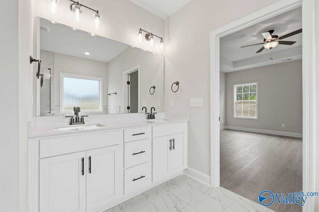 Elegant master bathroom with double vanity, large mirrors, and window in Davidson Homes The Rockford B, Hartselle, Alabama