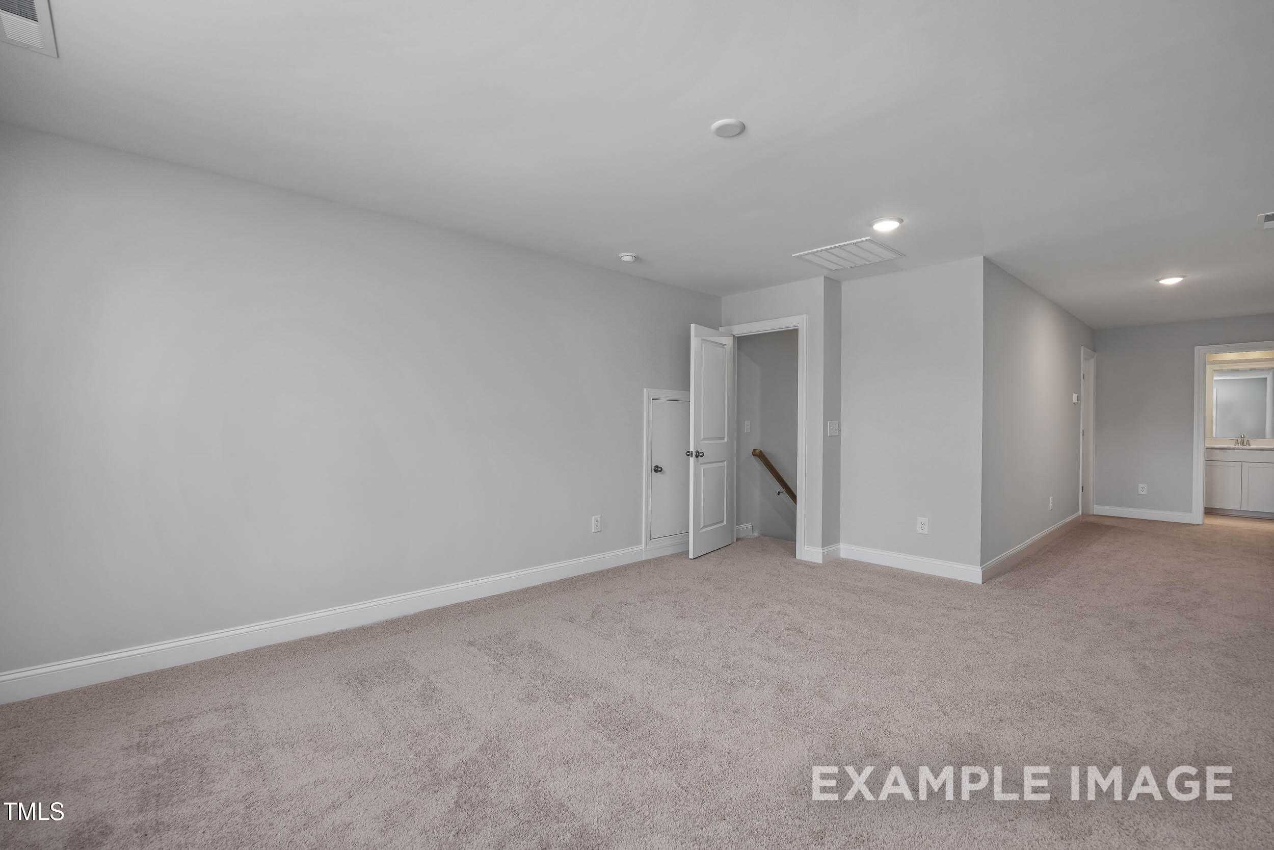 Spacious upstairs hallway with gray walls, beige carpet, staircase, and bathroom sink in Davidson Homes The Beech B, Raleigh NC