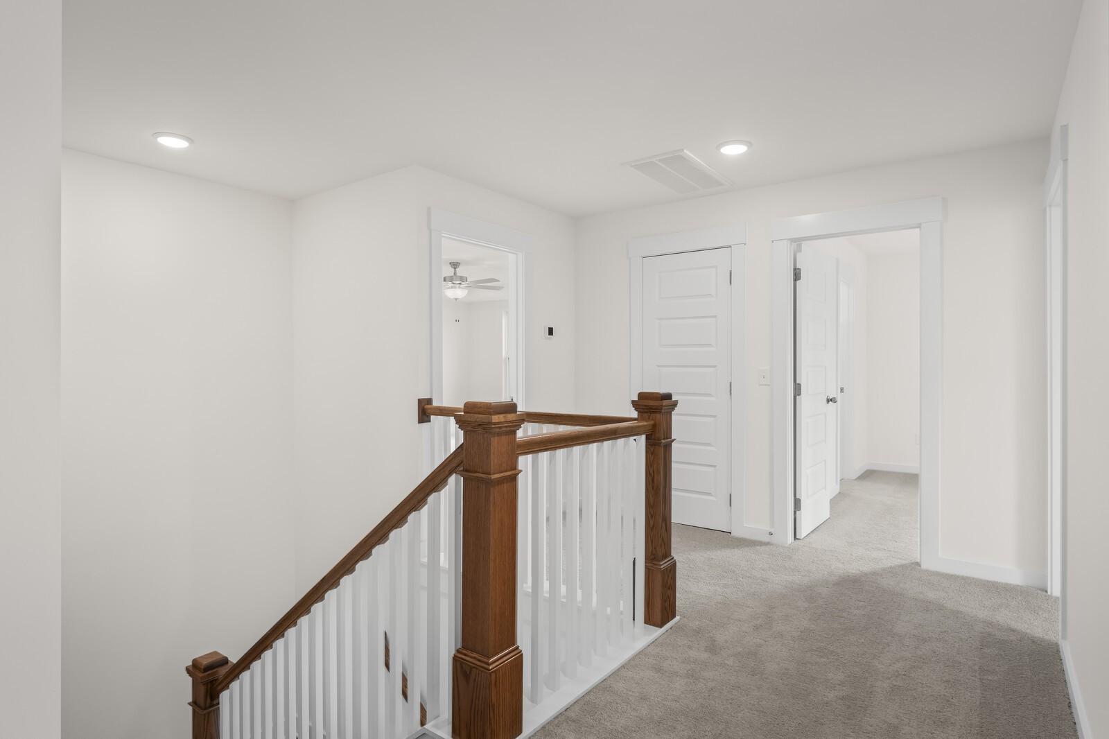Bright second-floor landing with wood railing in The Henry C floor plan at Benders Cove, Mt. Juliet, Tennessee.