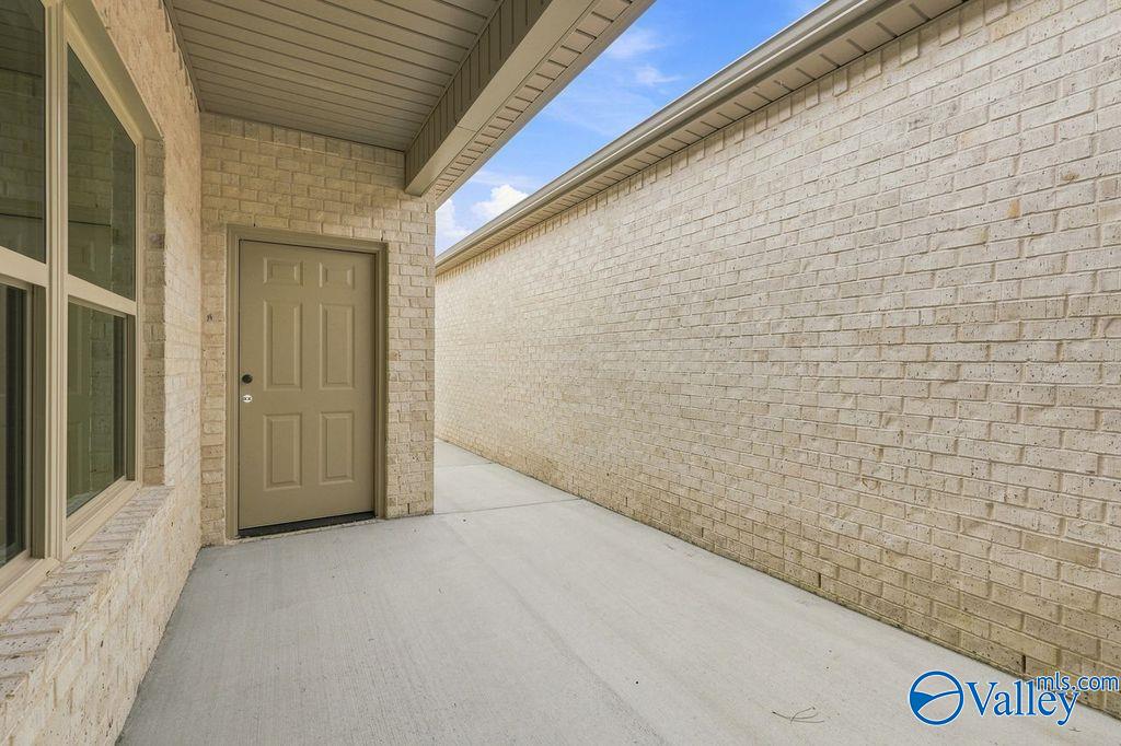 Covered side patio with tan brick exterior of The Camilla C floor plan at The Retreat at Cain Park in Hartselle, Alabama.