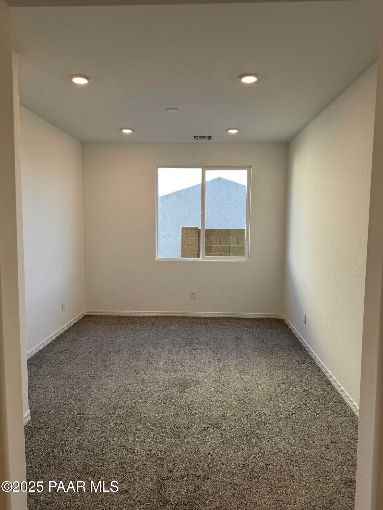 Empty bedroom with gray carpet, white walls, large window, and recessed lights in Davidson Homes Sunrise II A, Prescott, AZ