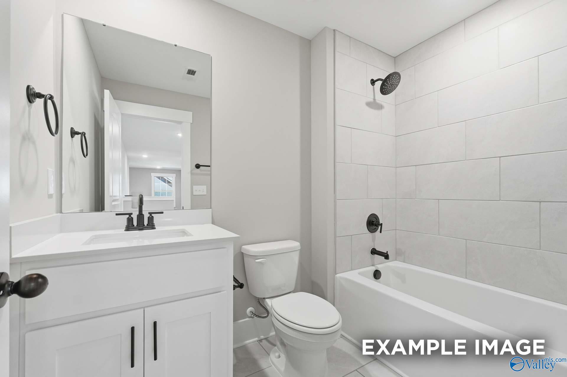 Modern bathroom with white subway tile shower, soaking tub, and double vanity in Davidson Homes The Emory, Decatur AL