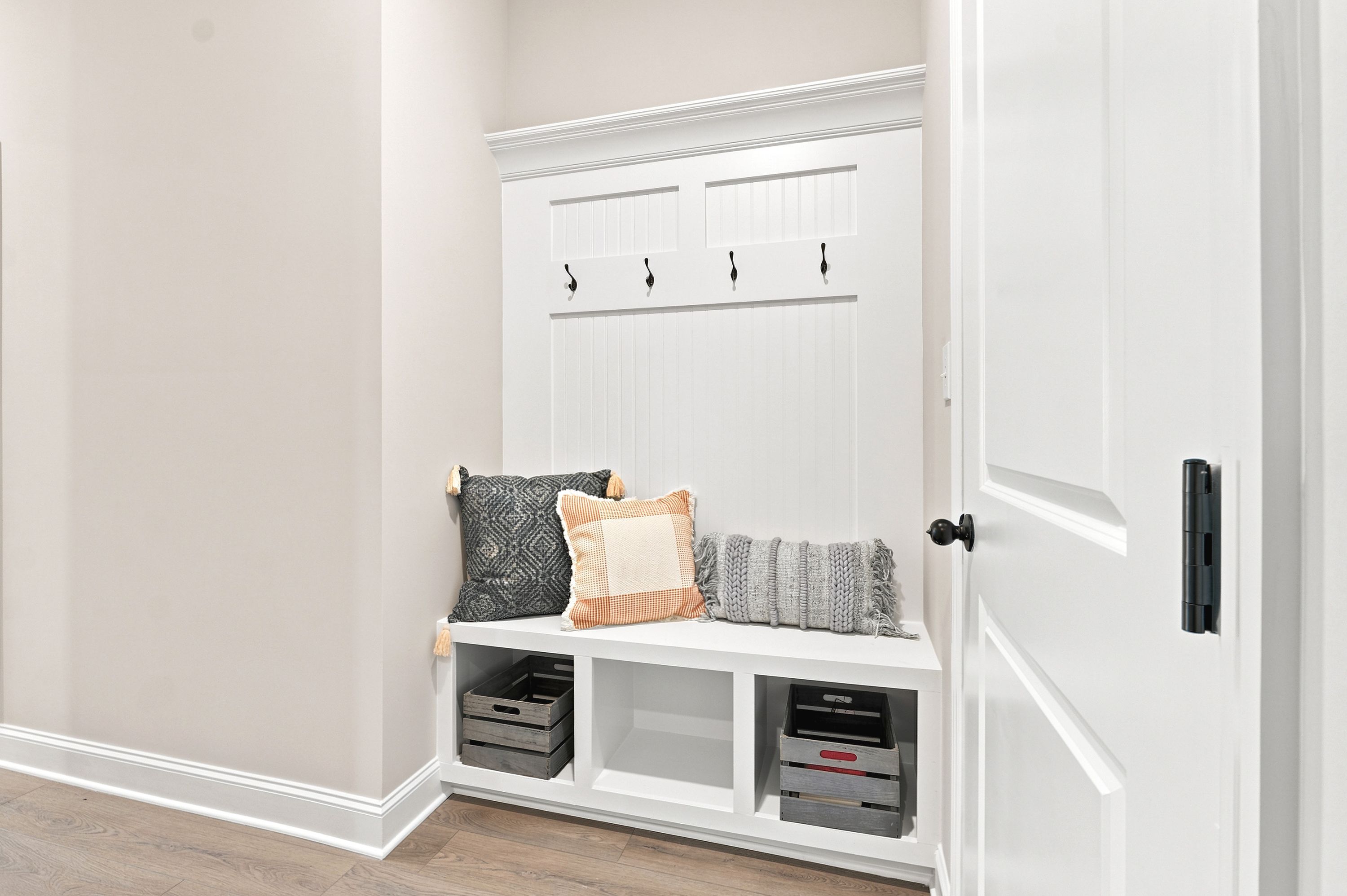 Built-in mudroom bench at Riverton Preserve in Huntsville, AL by Davidson Homes with storage cubbies and coat hooks.