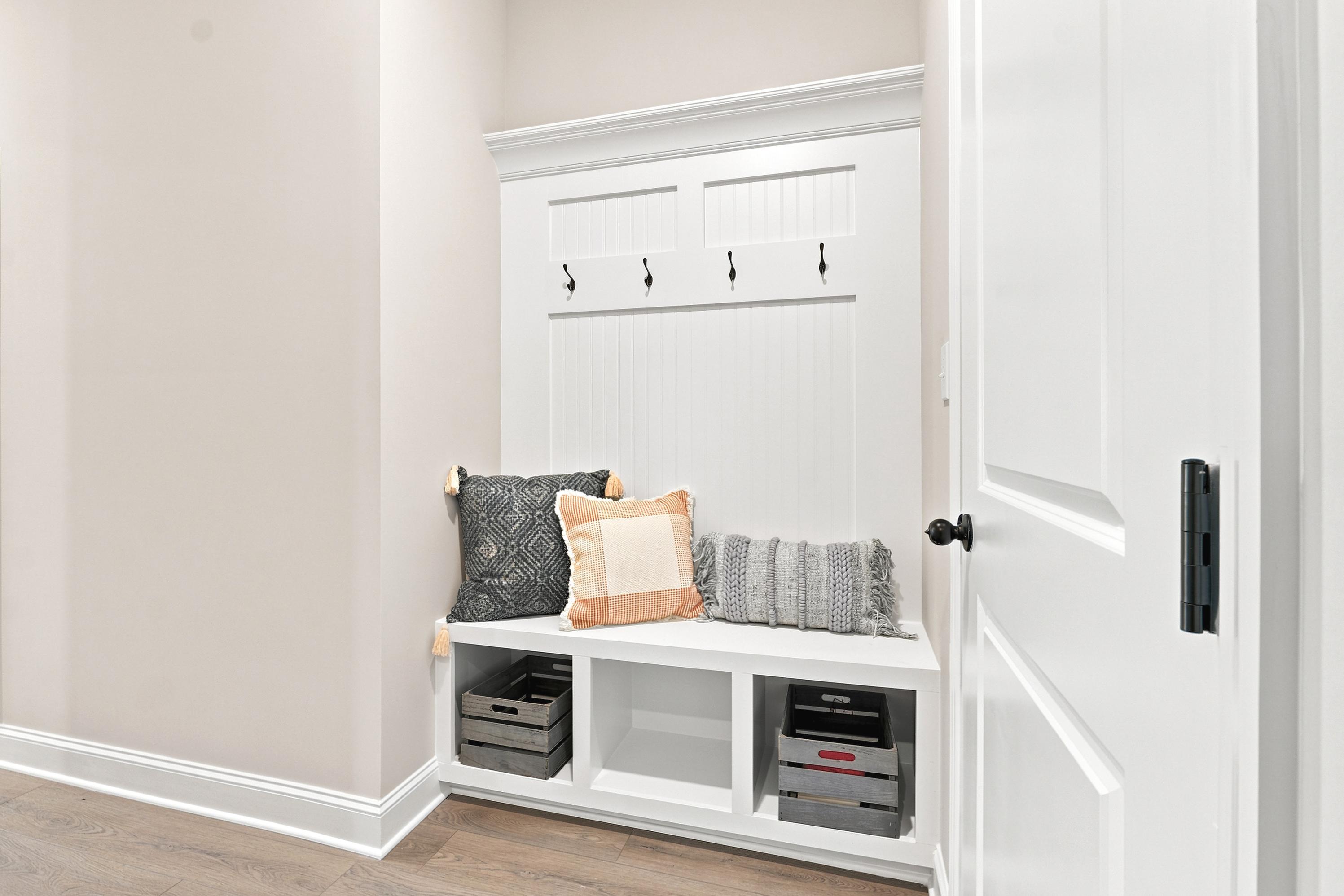 Built-in mudroom bench at Riverton Preserve in Huntsville, AL by Davidson Homes with storage cubbies and coat hooks.
