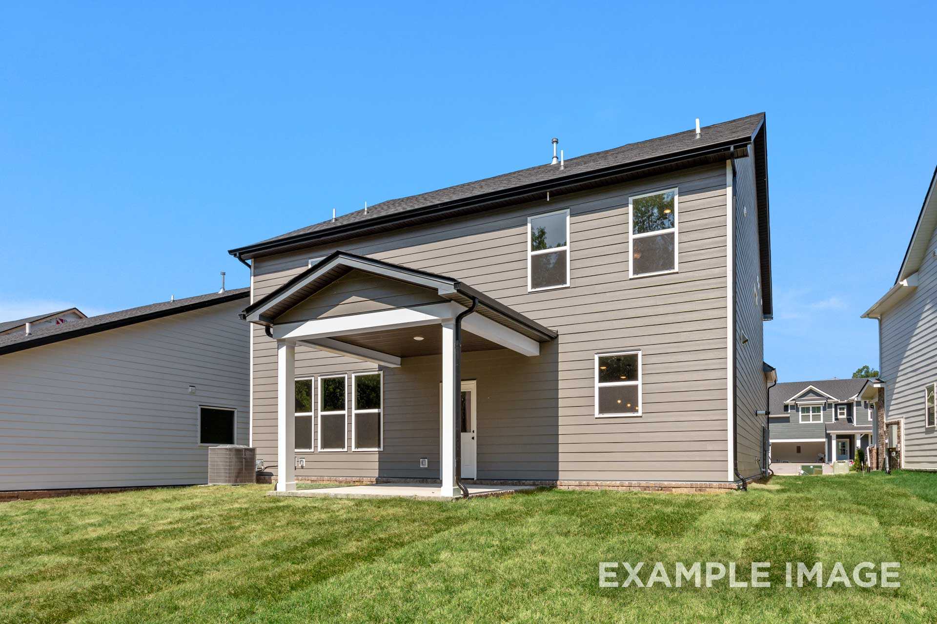 Two-story The Henry B home elevation with gray siding, covered porch, large windows, and attached 2-car garage on lush green lawn