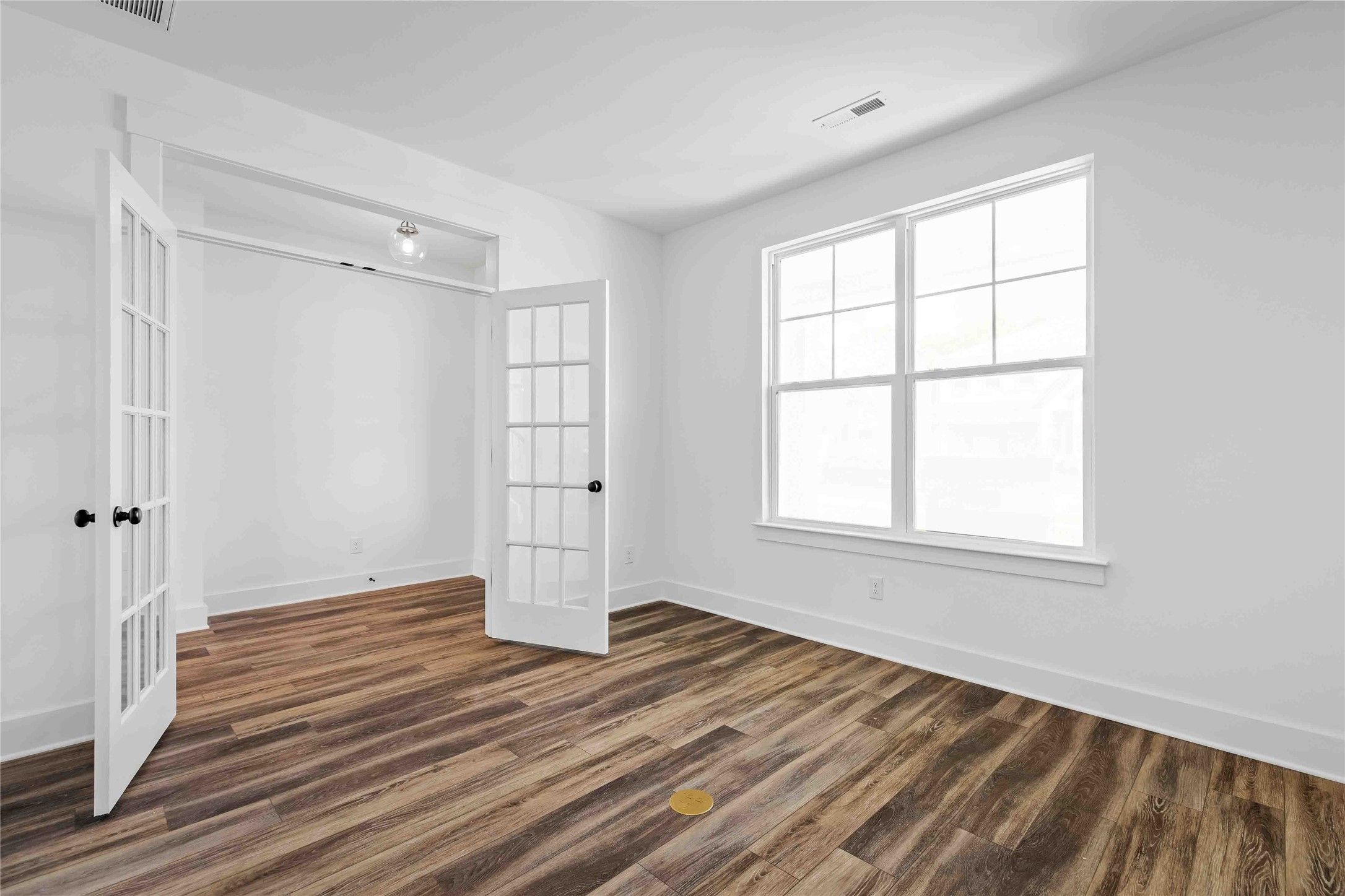 Bright home office or flex room with French doors and wood-look flooring in The Ash O floor plan, Heartland, Texas.
