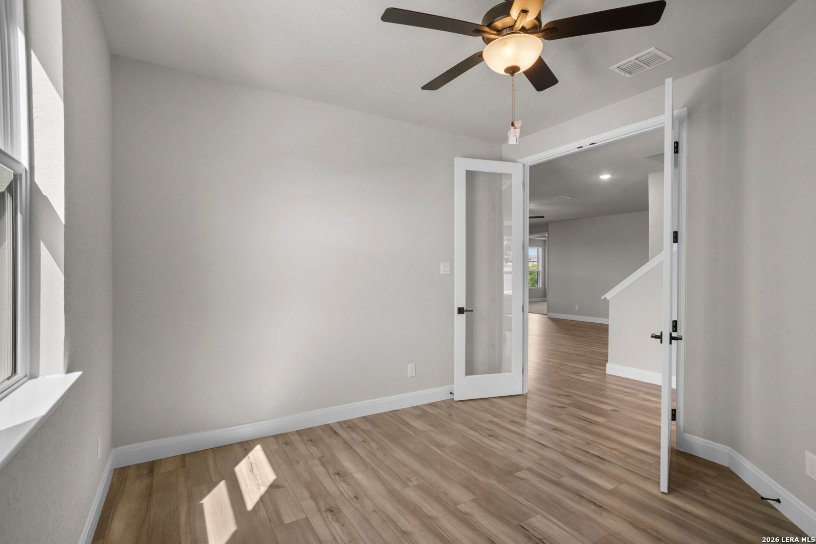 Bright home office with French doors and wood-look flooring in The Jennings G floor plan by Davidson Homes in Ladera.