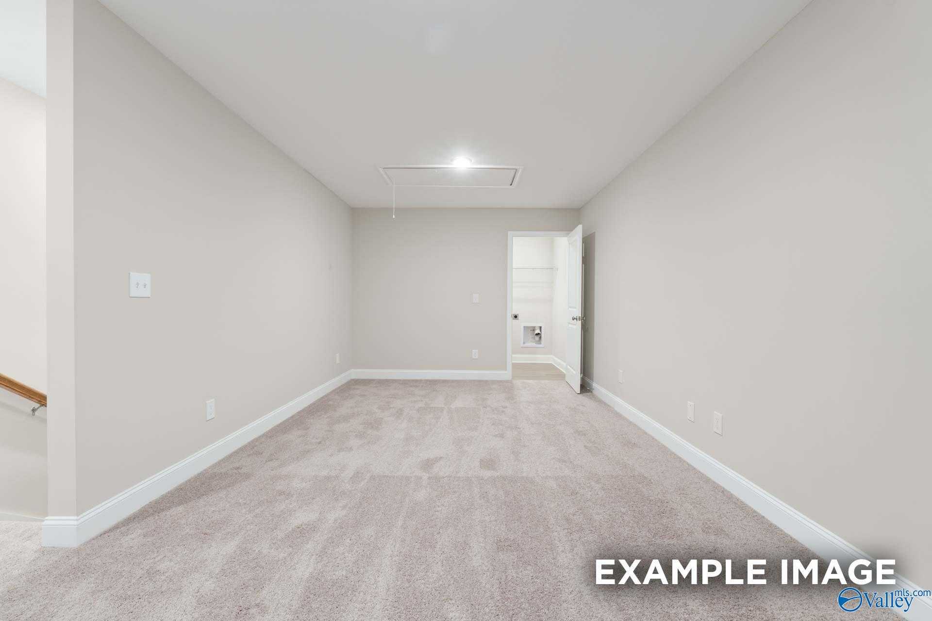 Spacious empty bonus room with beige walls, carpet flooring, and open doorway in Davidson Homes The Camden C, Huntsville