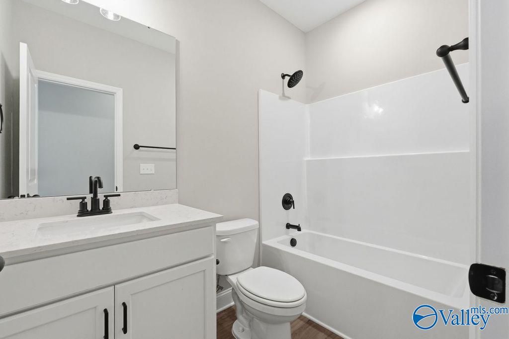 Modern bathroom with white vanity, quartz countertop, and tub-shower combo in The Rockford home at Cain Park, Hartselle.