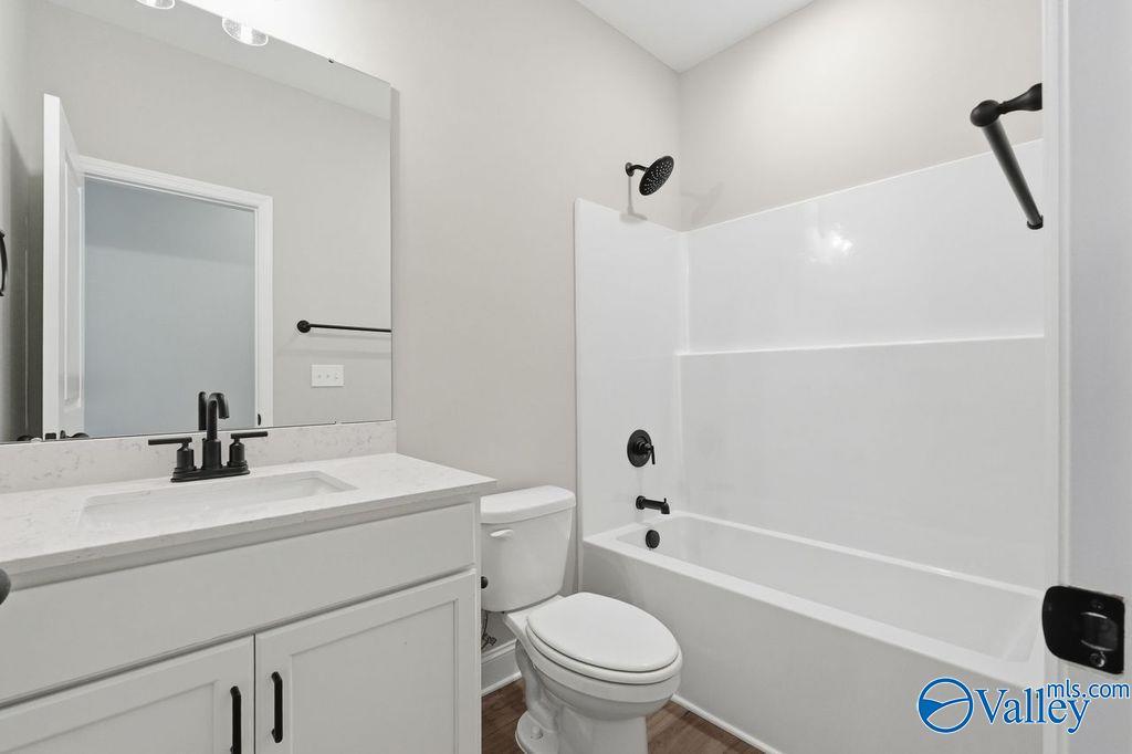 Modern bathroom with white vanity, quartz countertop, and tub-shower combo in The Rockford home at Cain Park, Hartselle.