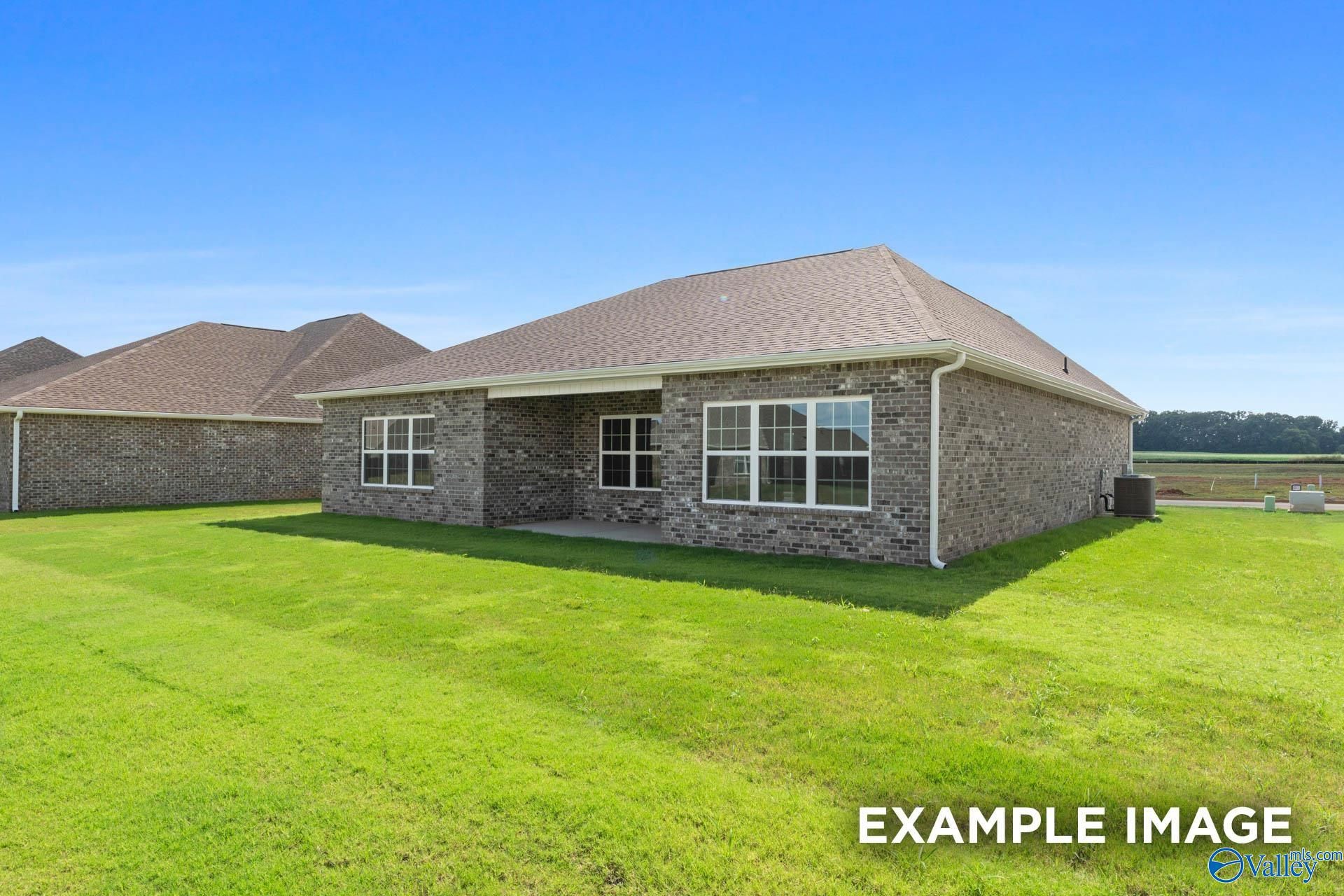 Single-story brick 3-bedroom home with covered porch, large windows, and lush green lawn in Cain Park, Hartselle, Alabama