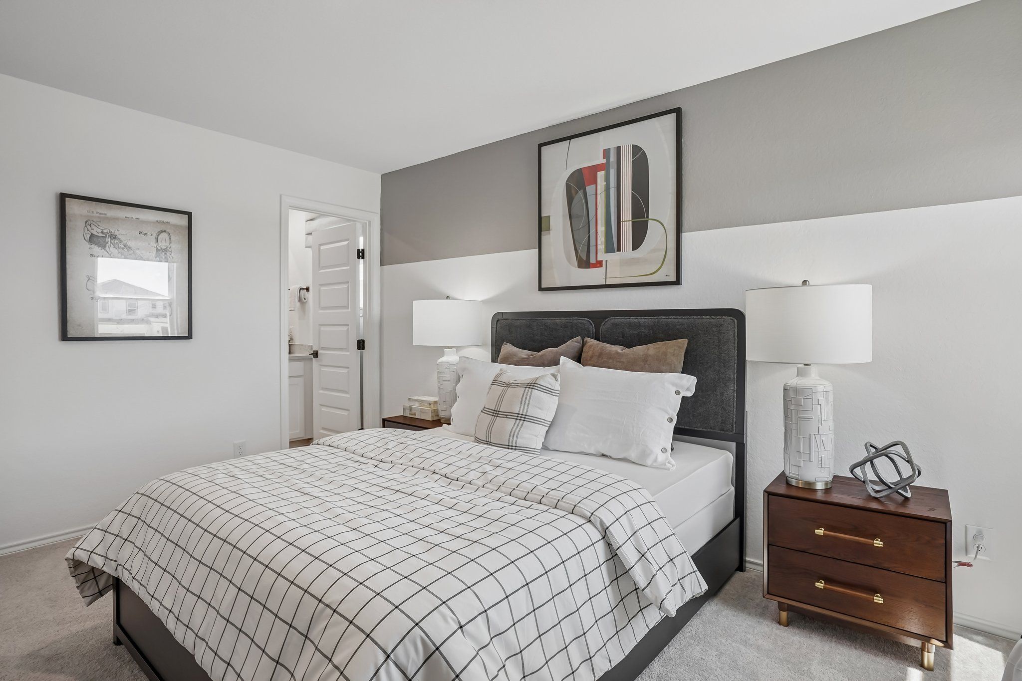 Modern bedroom with upholstered headboard and plaid bedding at Fairway Crossing in Converse, Texas by Davidson Homes.