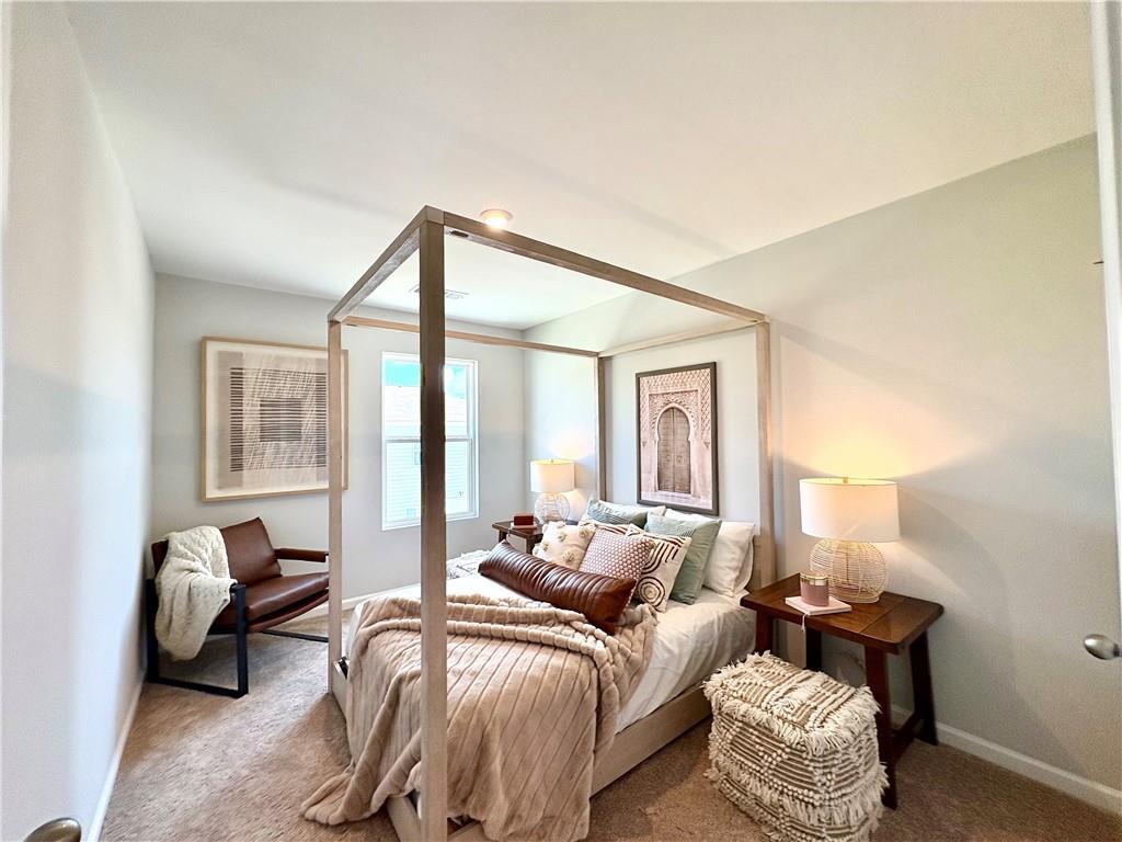 Cozy bedroom with canopy bed, neutral bedding, and modern accents in Davidson Homes The Monroe A, Emerson, Georgia