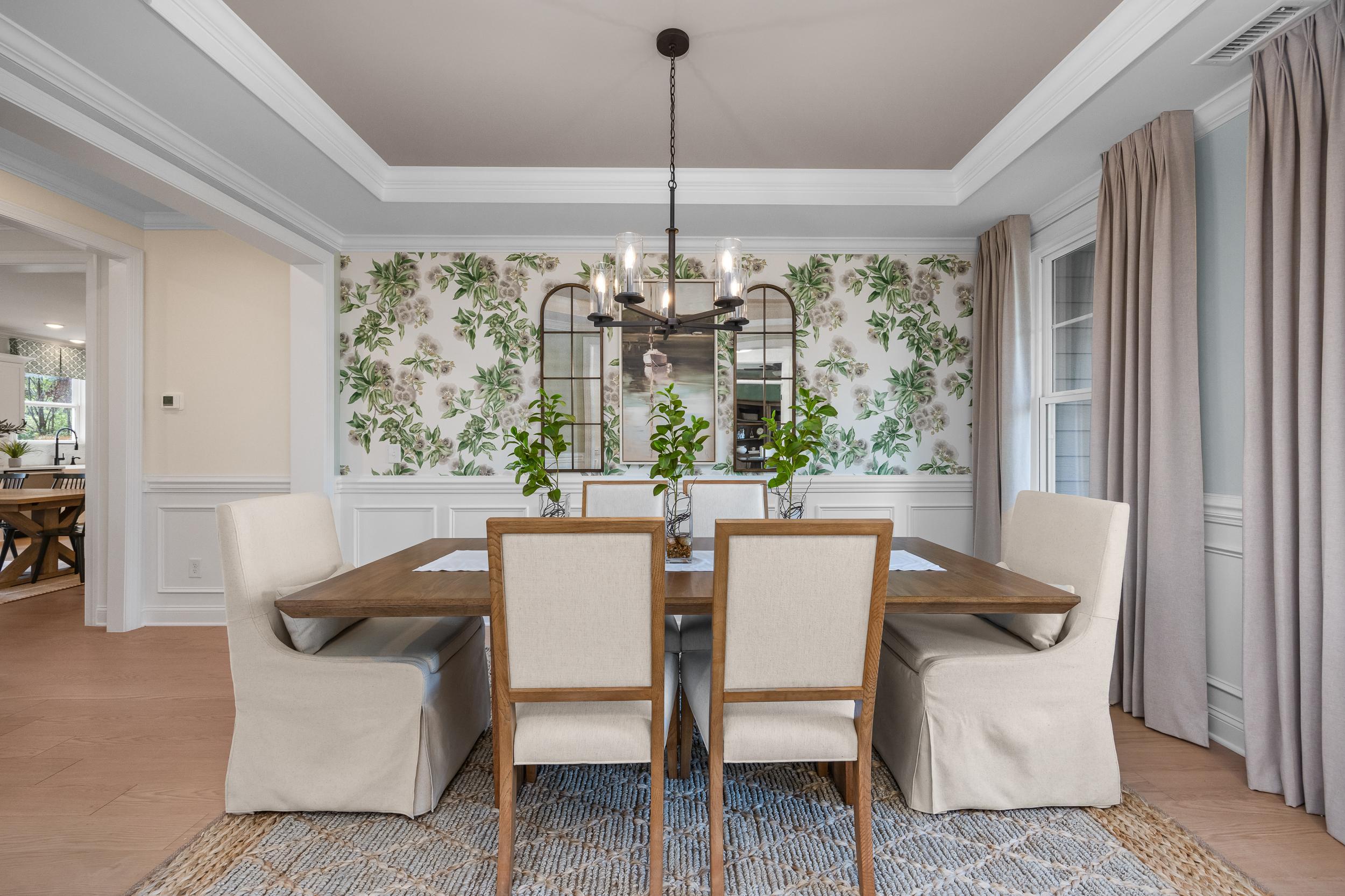 Elegant dining room at Laneridge Estates in Raleigh NC with wooden table, beige chairs, chandelier, and floral wallpaper