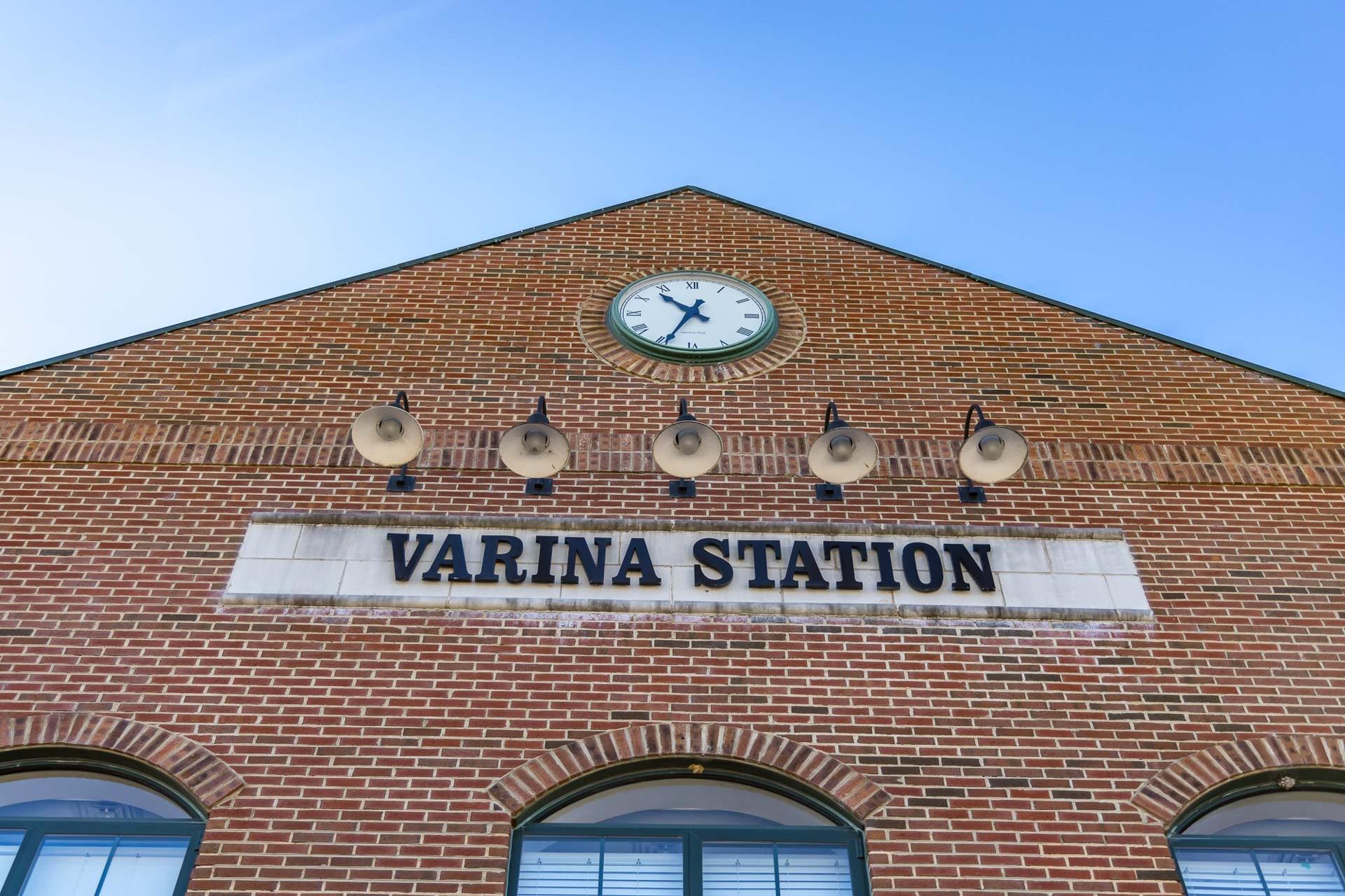 Brick Varina Station facade in Fuquay-Varina NC with gabled roof, large clock, pendant lights, and arched windows