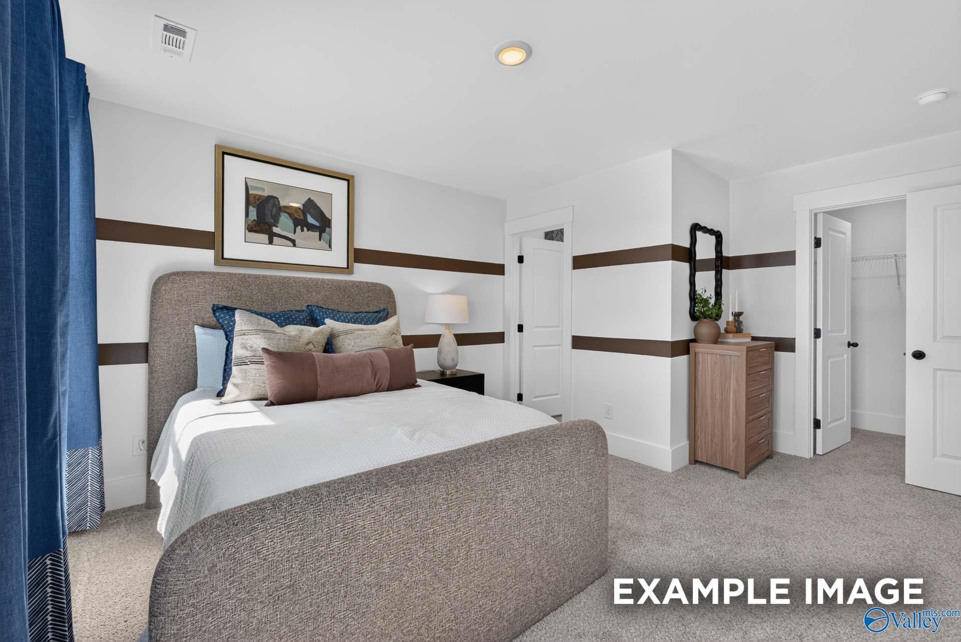Cozy primary bedroom with upholstered bed, accent walls, and walk-in closet in The Ashport K floor plan at Forest Glen, Hazel Green
