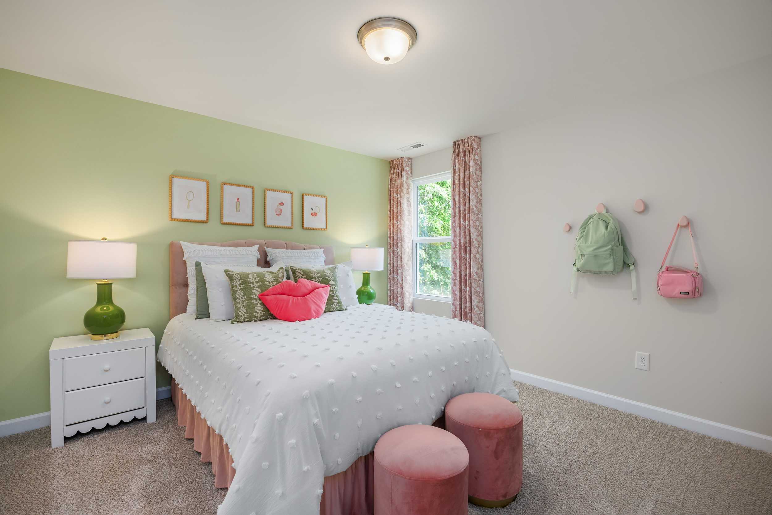 Charming girl's bedroom at Retreat at North Main in Lillington NC featuring green walls, pink accents, cozy white bed and window seat