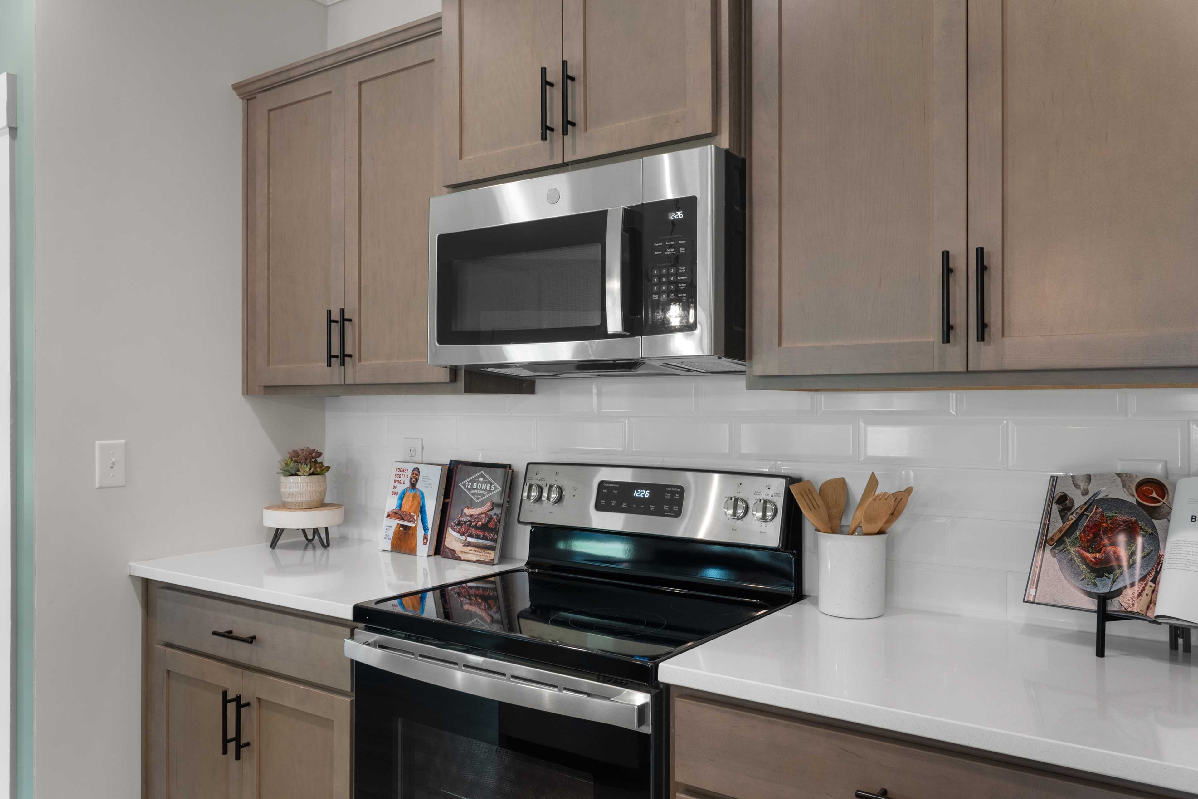 Modern kitchen in Hollon Meadow Decatur Alabama with shaker cabinets stainless steel appliances white subway tile backsplash