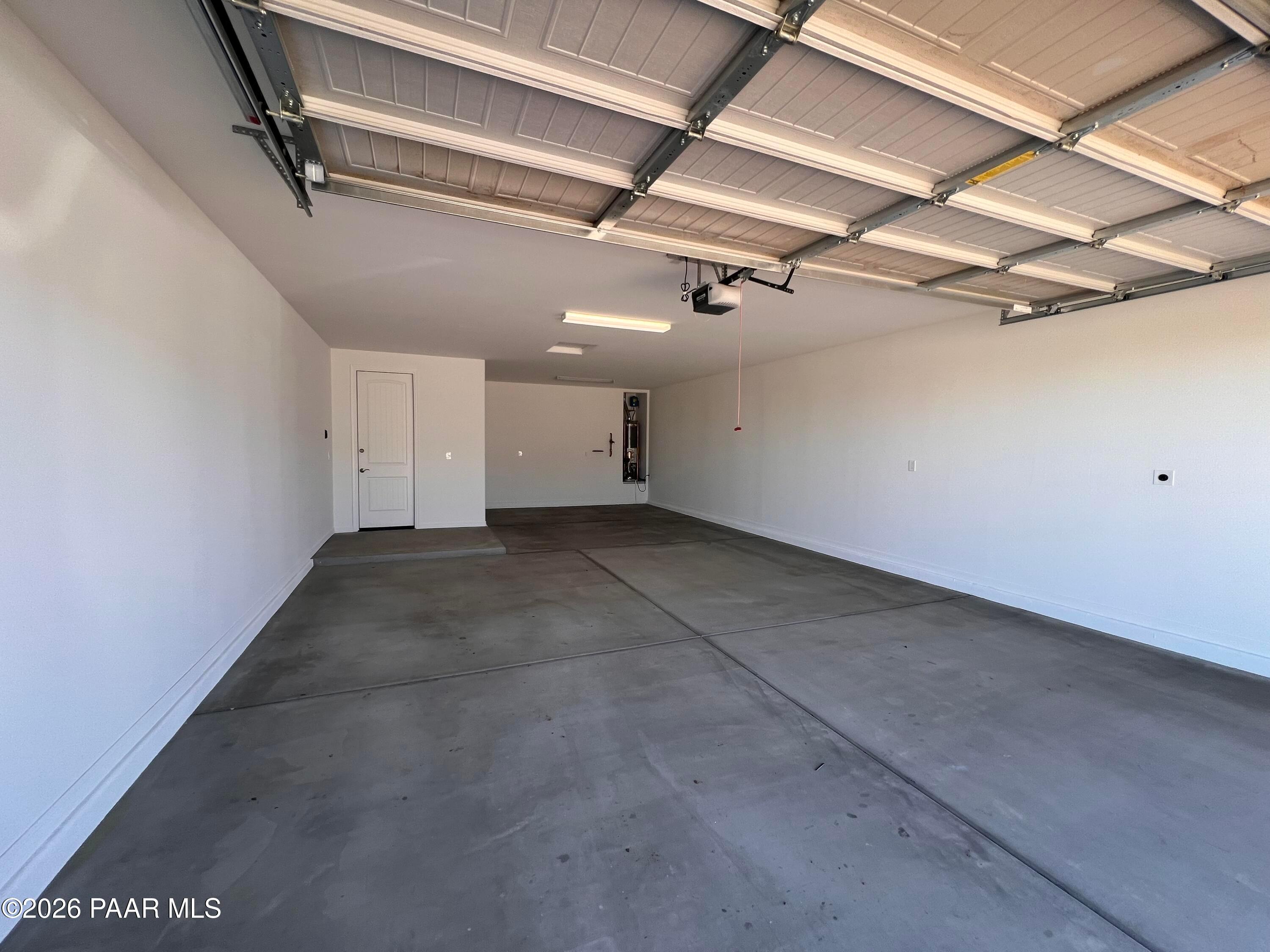 Spacious 3-car garage with polished concrete floors, white walls, and built-in storage in Davidson Homes The Sunrise II A, Prescott, AZ