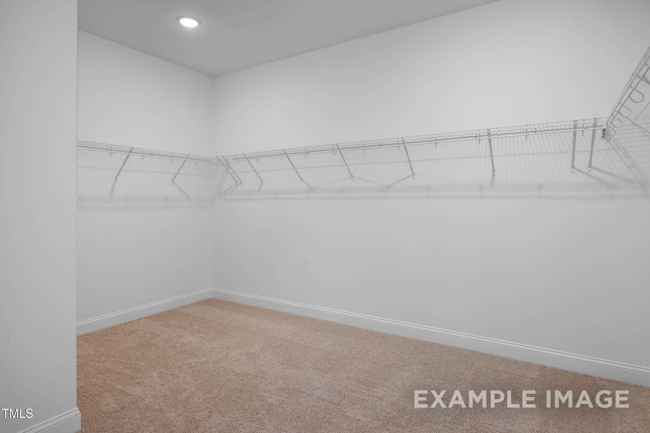 Spacious walk-in closet with wire shelving and beige carpet in Davidson Homes The Beech B, Raleigh, North Carolina