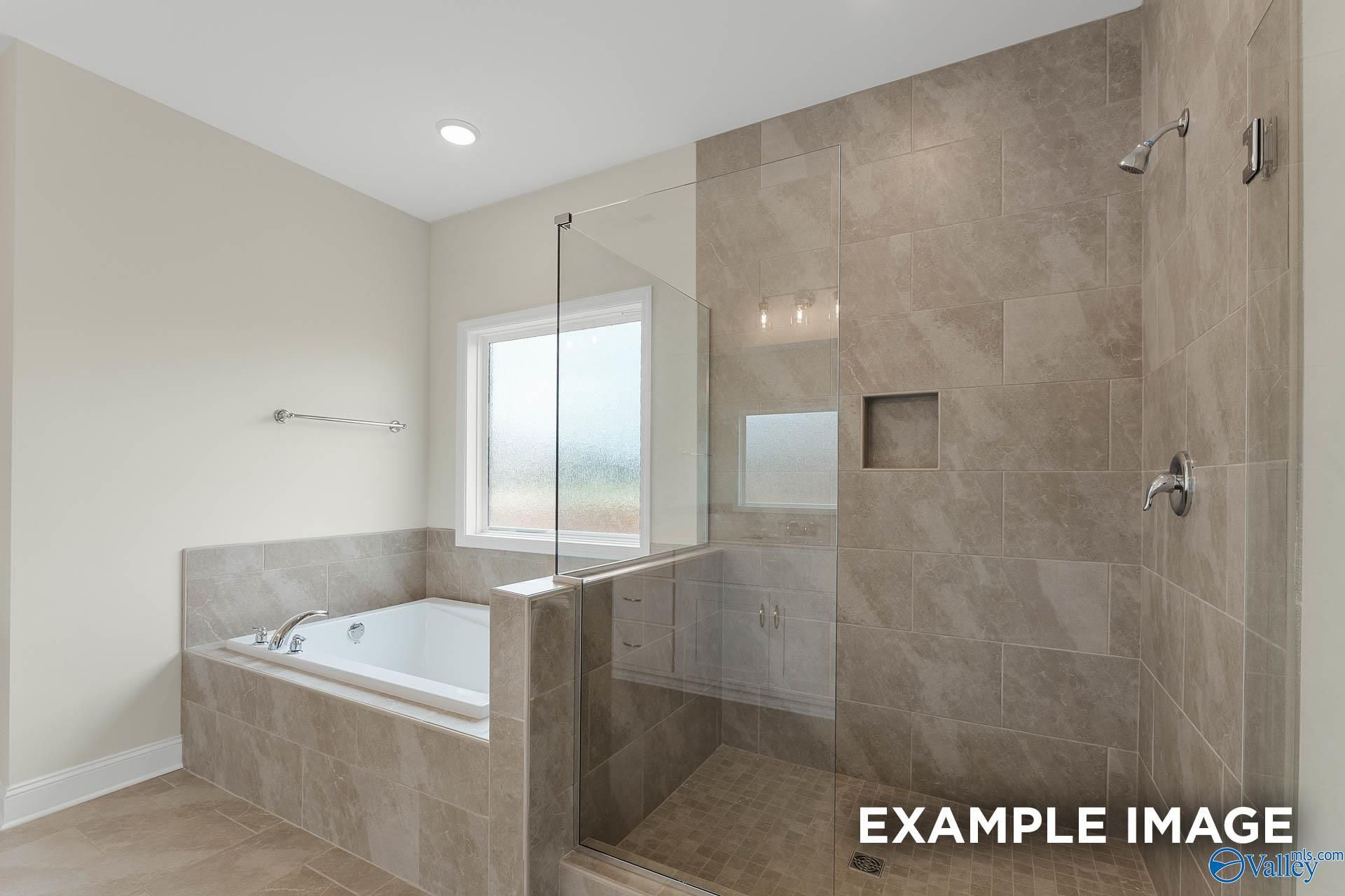 Modern master bathroom with freestanding tub and glass-enclosed shower in Davidson Homes The Emory, Toney, Alabama