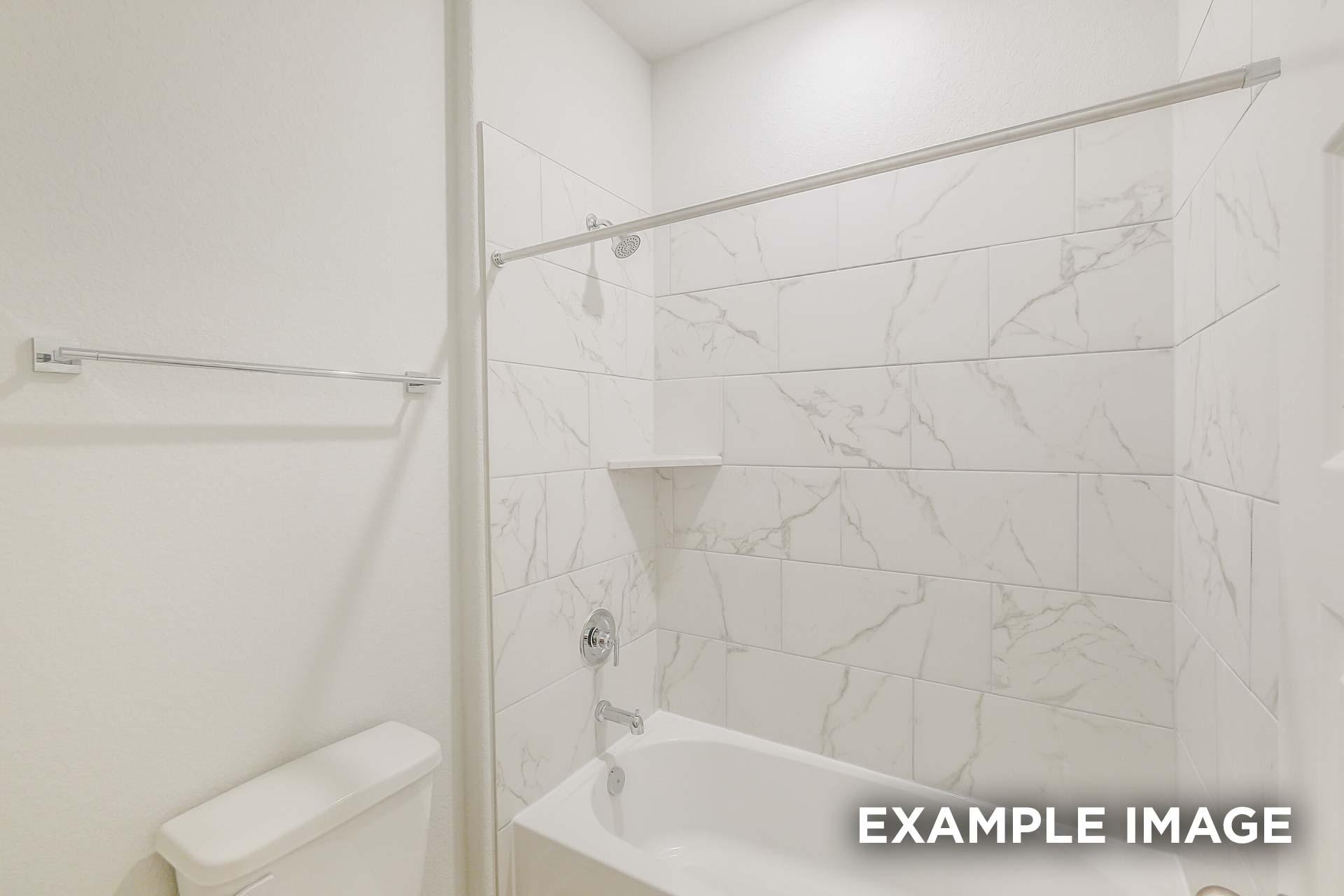 Modern bathroom in The Luna J showcasing white marble porcelain tile shower-tub combo, soaking tub, and sleek fixtures