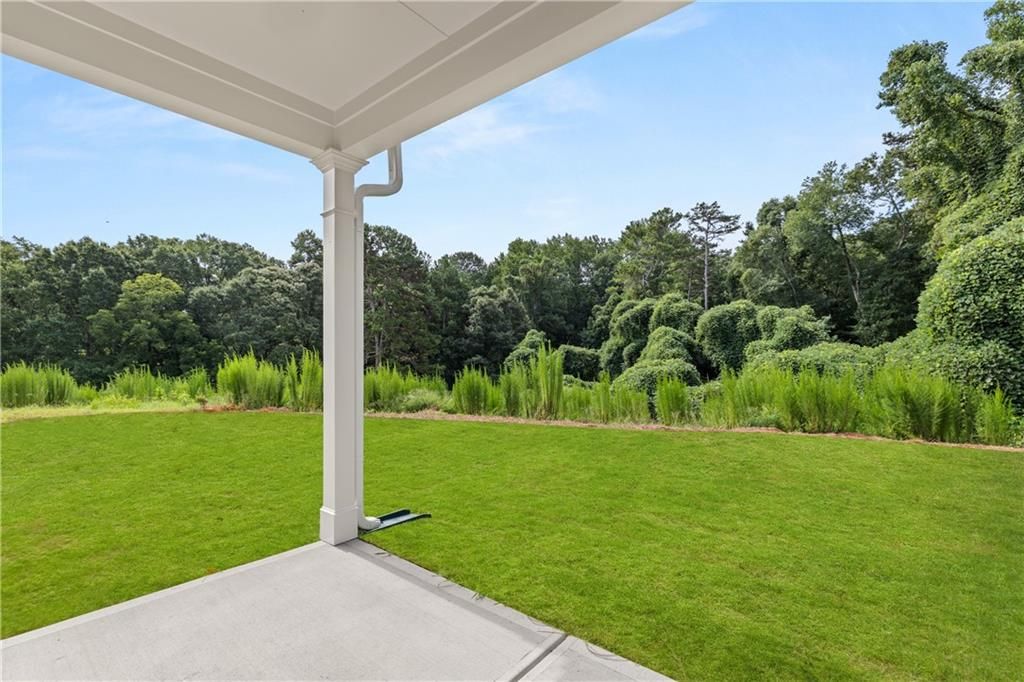 Covered patio with scenic backyard view at The Russell A floor plan in Cedar Farms, Winder, Georgia.
