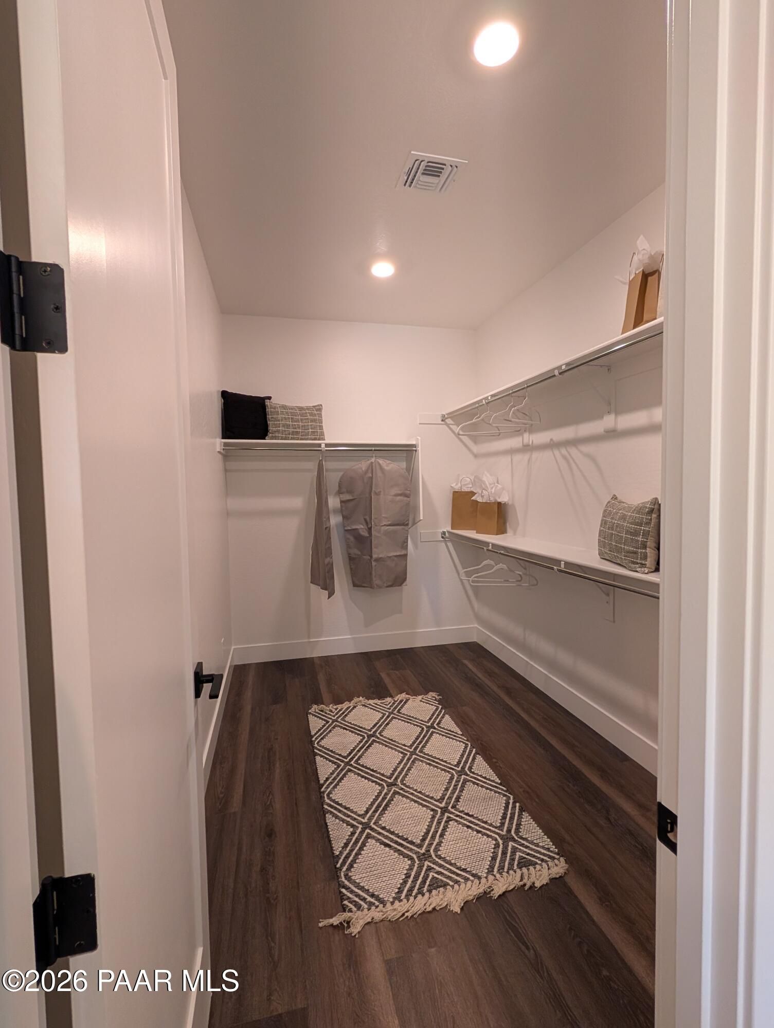Walk-in closet with shelving and wood flooring in The Boulder II H at South Ranch Western Collection, Prescott, Arizona.