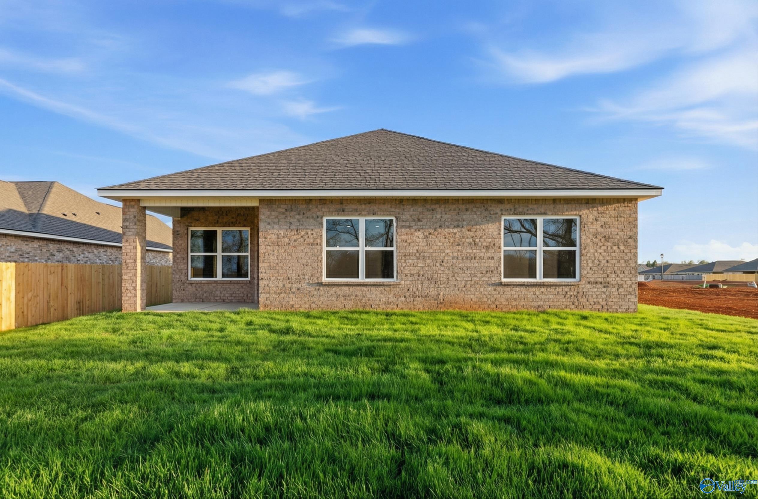 Single-story brick home with gabled roof, covered porch, large windows, and lush green lawn in Ivy Hills, Toney, Alabama - Davidson Homes Daphne C