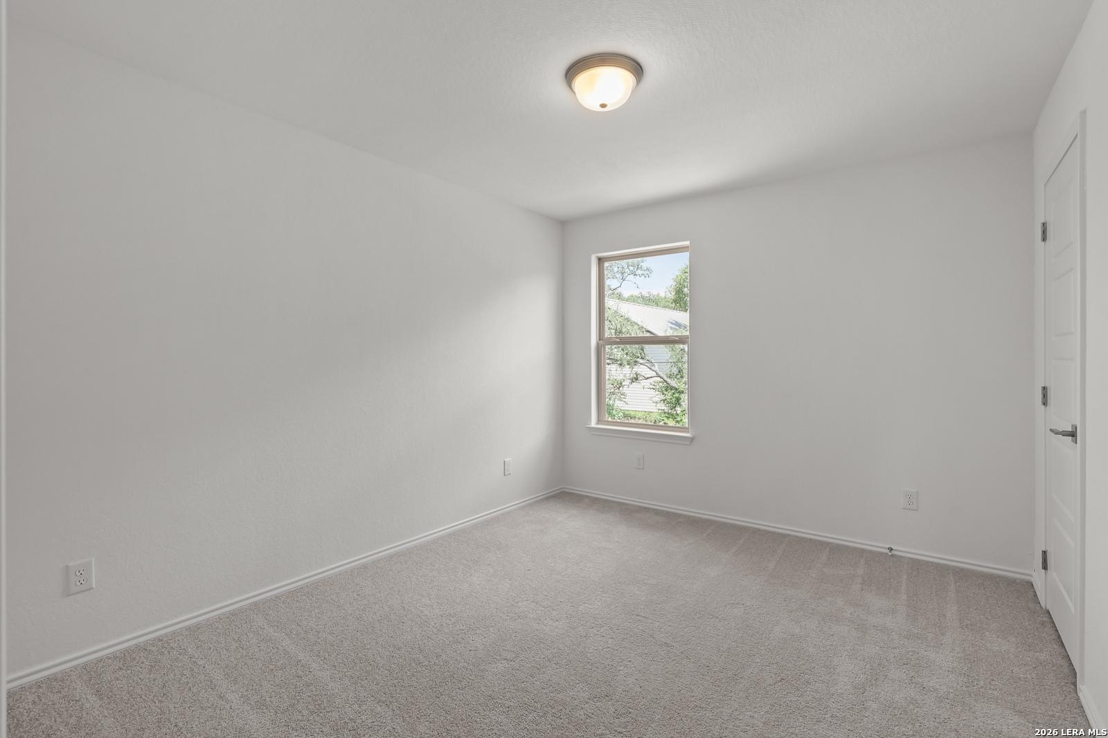 Bright, neutral bedroom with plush carpeting in The Gillian C floor plan at Meadows at Oak Creek, San Antonio, Texas.