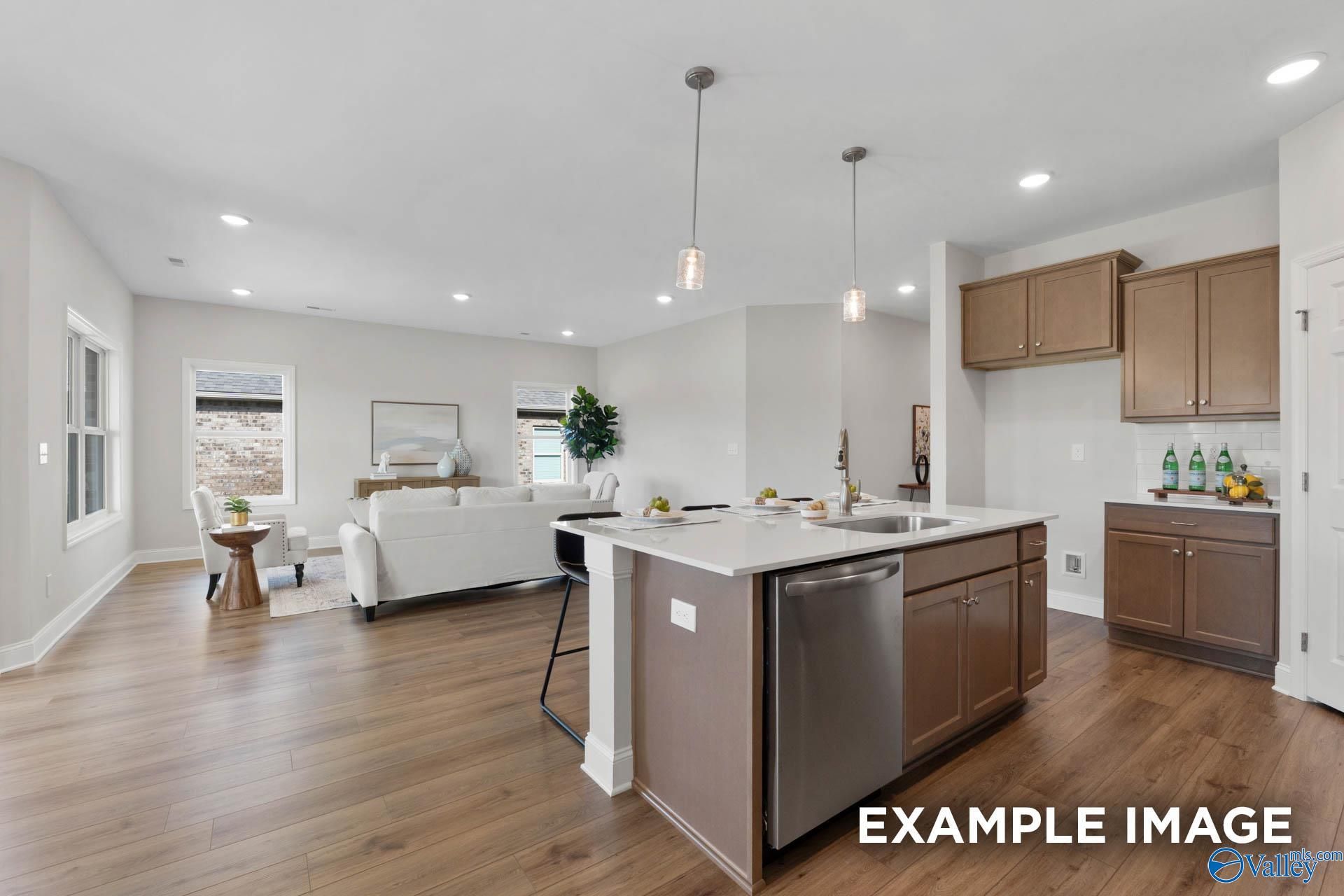 Open-concept kitchen with island and living area in The Franklin C floor plan at Heritage Lakes, New Market, Alabama.