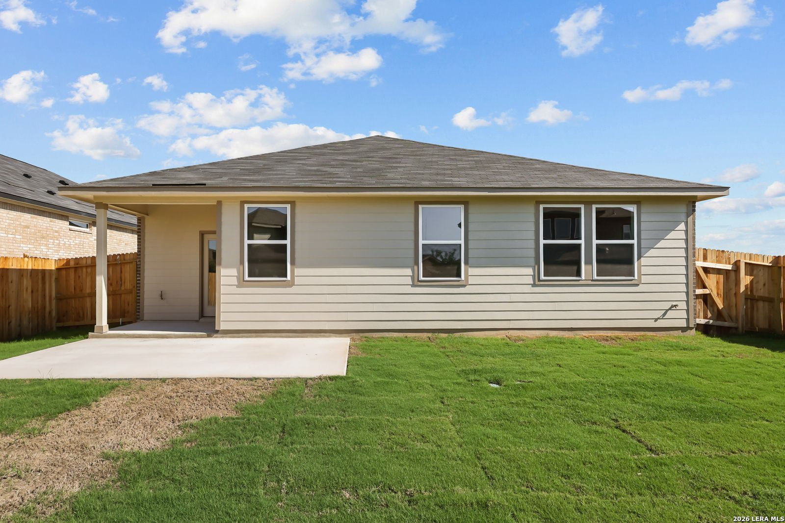 Rear exterior of Davidson Homes The Daphne I with covered patio, concrete slab, and fenced backyard in Bricewood, San Antonio, Texas