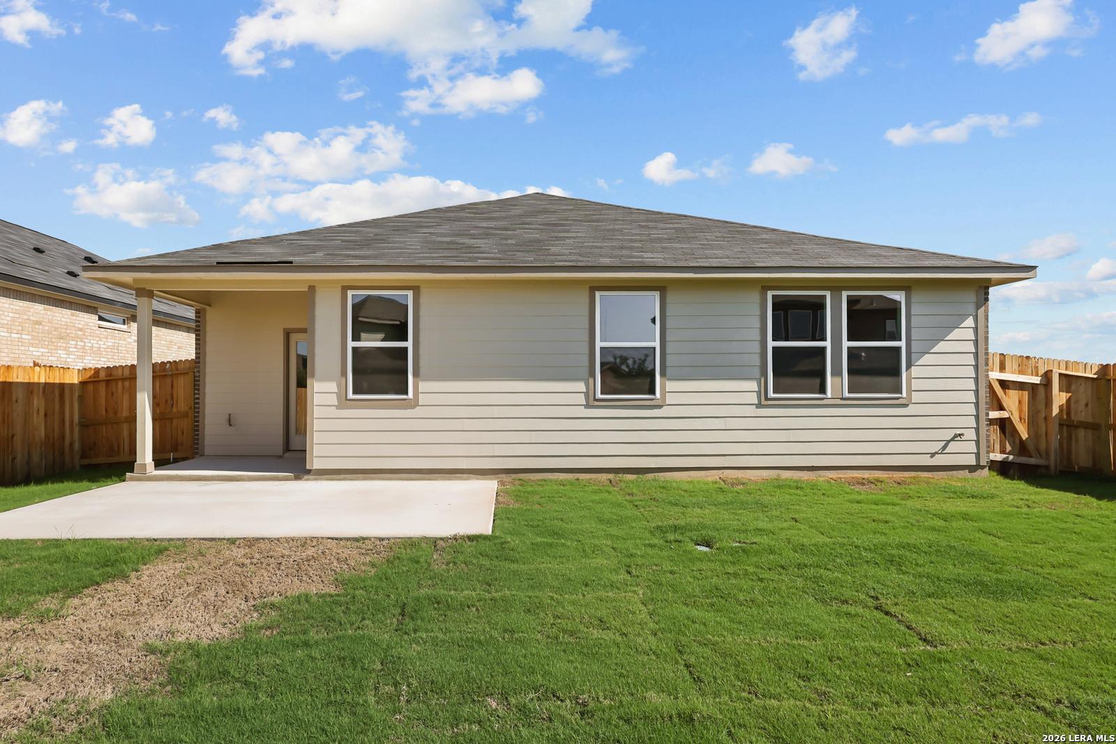 Rear exterior of Davidson Homes The Daphne I with covered patio, concrete slab, and fenced backyard in Bricewood, San Antonio, Texas