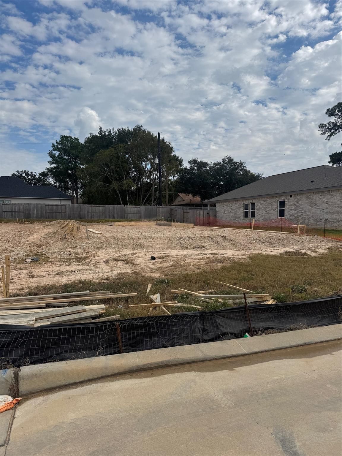 Construction site with wooden framing and lumber piles for The Sabine F 4-bedroom home by Davidson Homes in Windmill Estates, Magnolia, Texas
