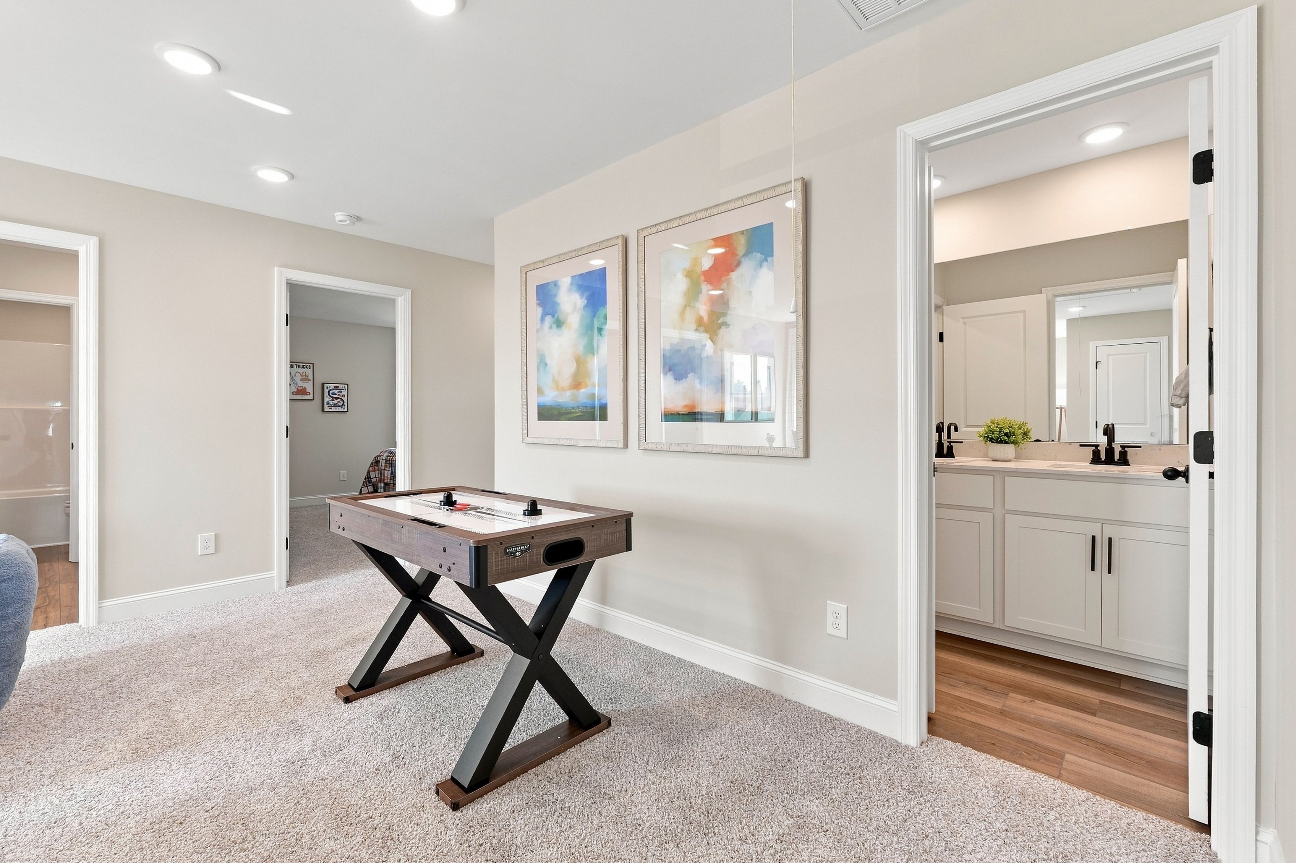 Spacious game room with air hockey table at Bailey Park by Davidson Homes in Fayetteville, Tennessee, near dual vanity bathroom