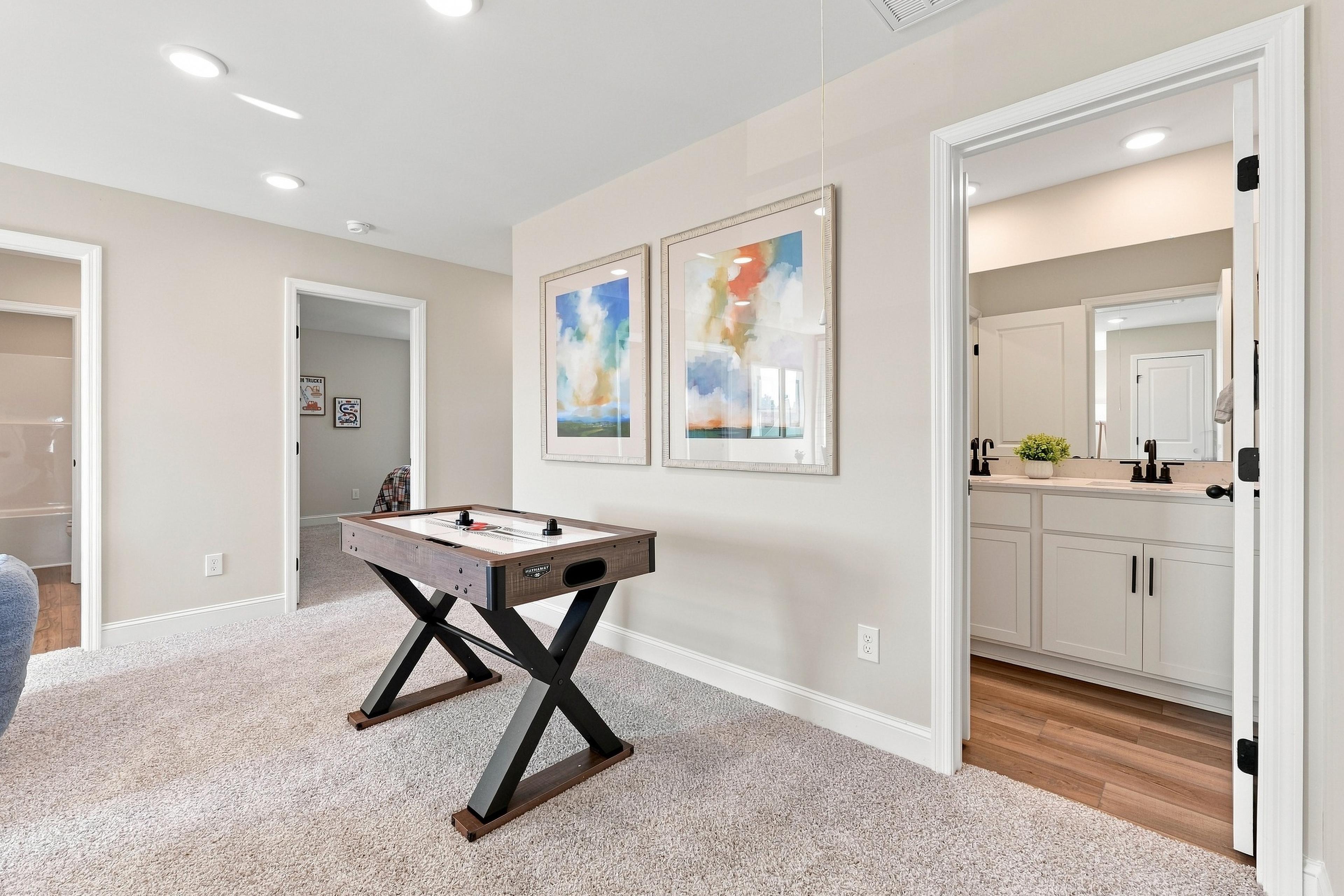 Spacious game room with air hockey table at Bailey Park by Davidson Homes in Fayetteville, Tennessee, near dual vanity bathroom